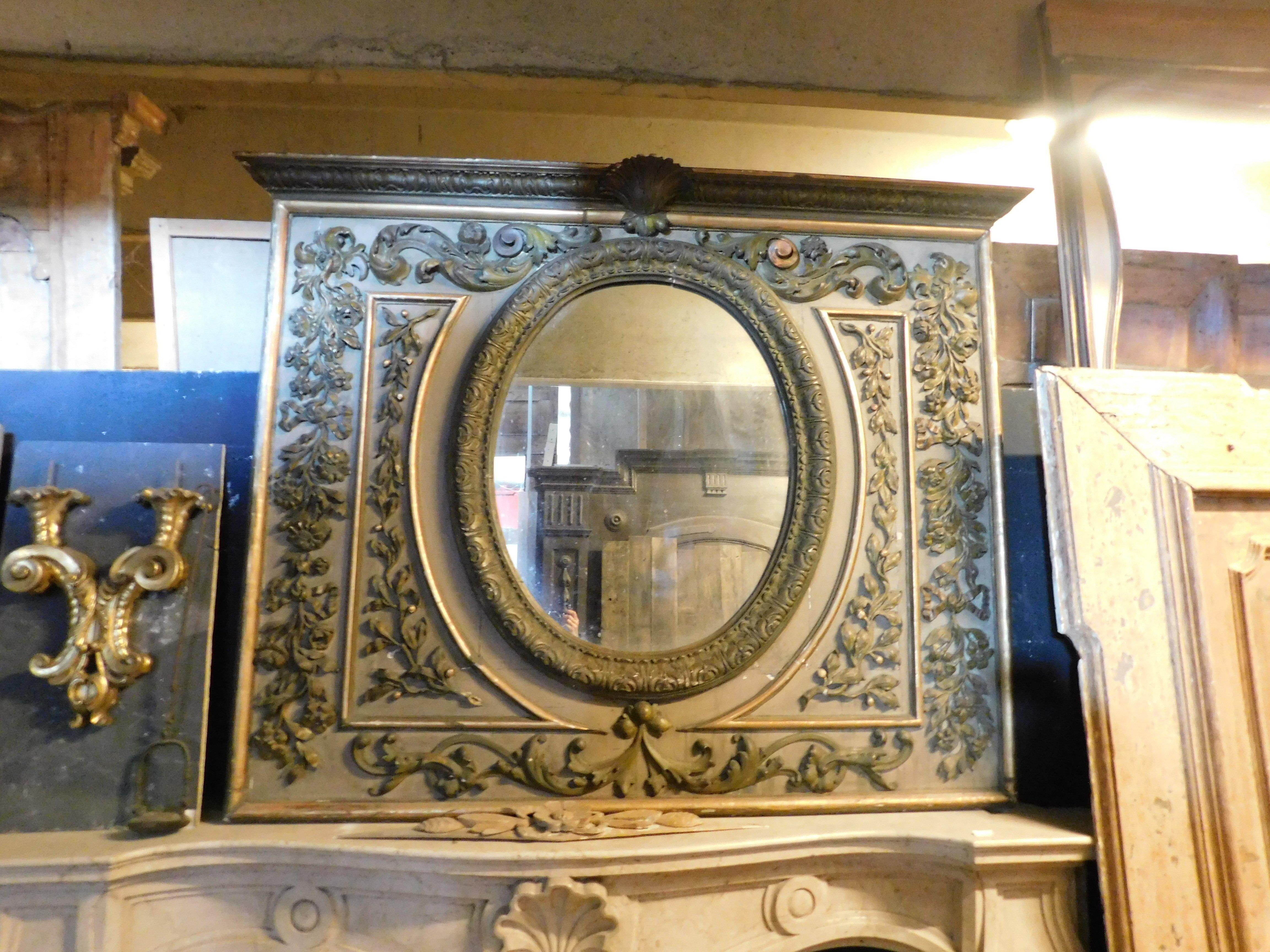 Specchio in legno laccato antico con ricchi intagli e successive decorazioni floreali e di foglie. Ha una conchiglia intagliata nella parte superiore e decorazioni in oro patinato, molto ricche e di grande impatto visivo. Ha uno specchio centrale