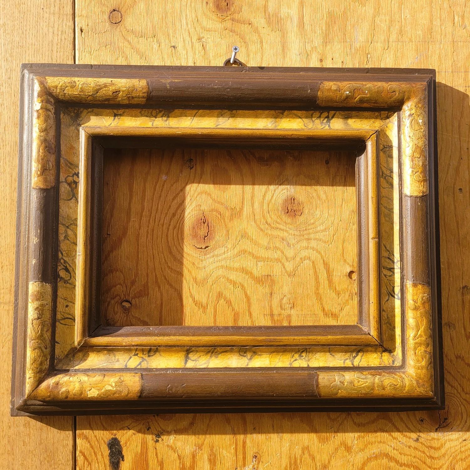 Lacquered and gilded wooden frame, painted to resemble marble, in the 17th-century style.  

Wear and chips consistent with age.  

Ideal for a mirror (sold as a frame, no mirror included.

   Late 19th/early 20th century.   

Frame dimensions: 38.5