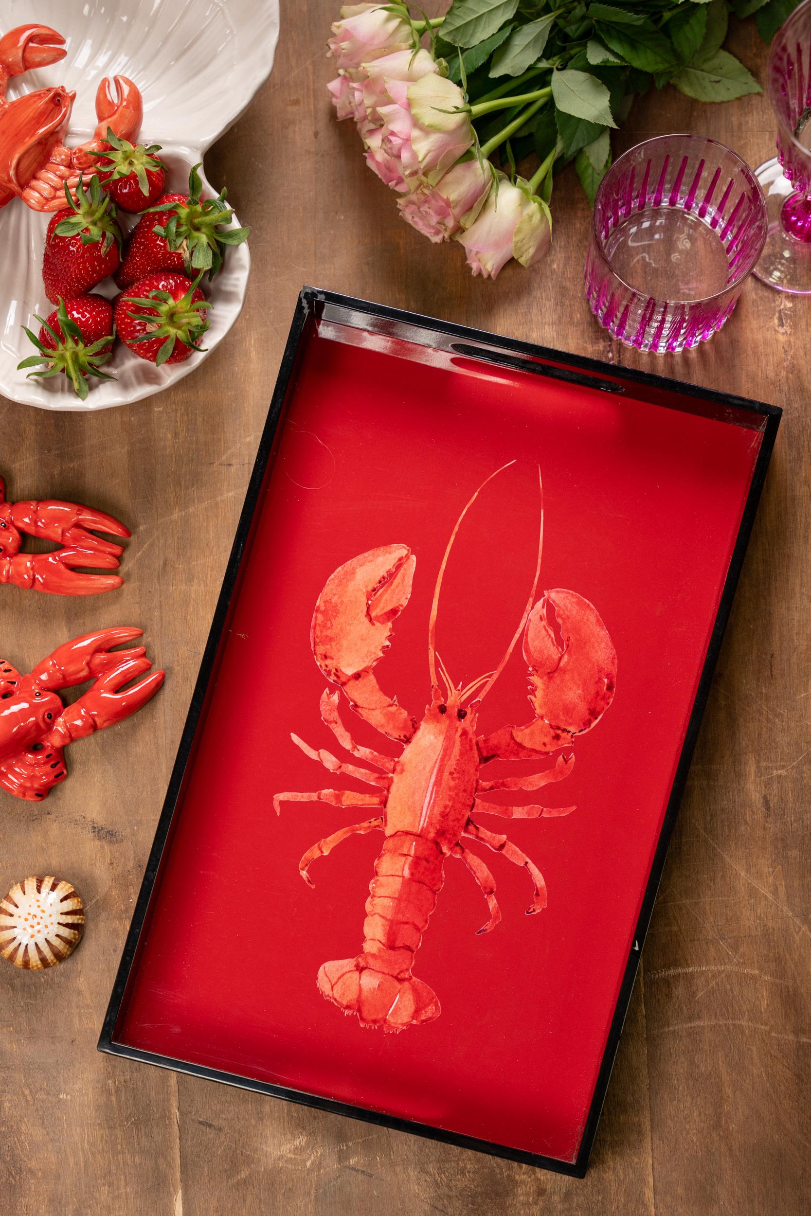 Audacieux et ludique, ce plateau en bois laqué présente un fond rouge vibrant orné d'un motif de homard saisissant. Doté d'une surface lisse et brillante et de poignées découpées pratiques, il est parfait pour servir des boissons, des apéritifs ou