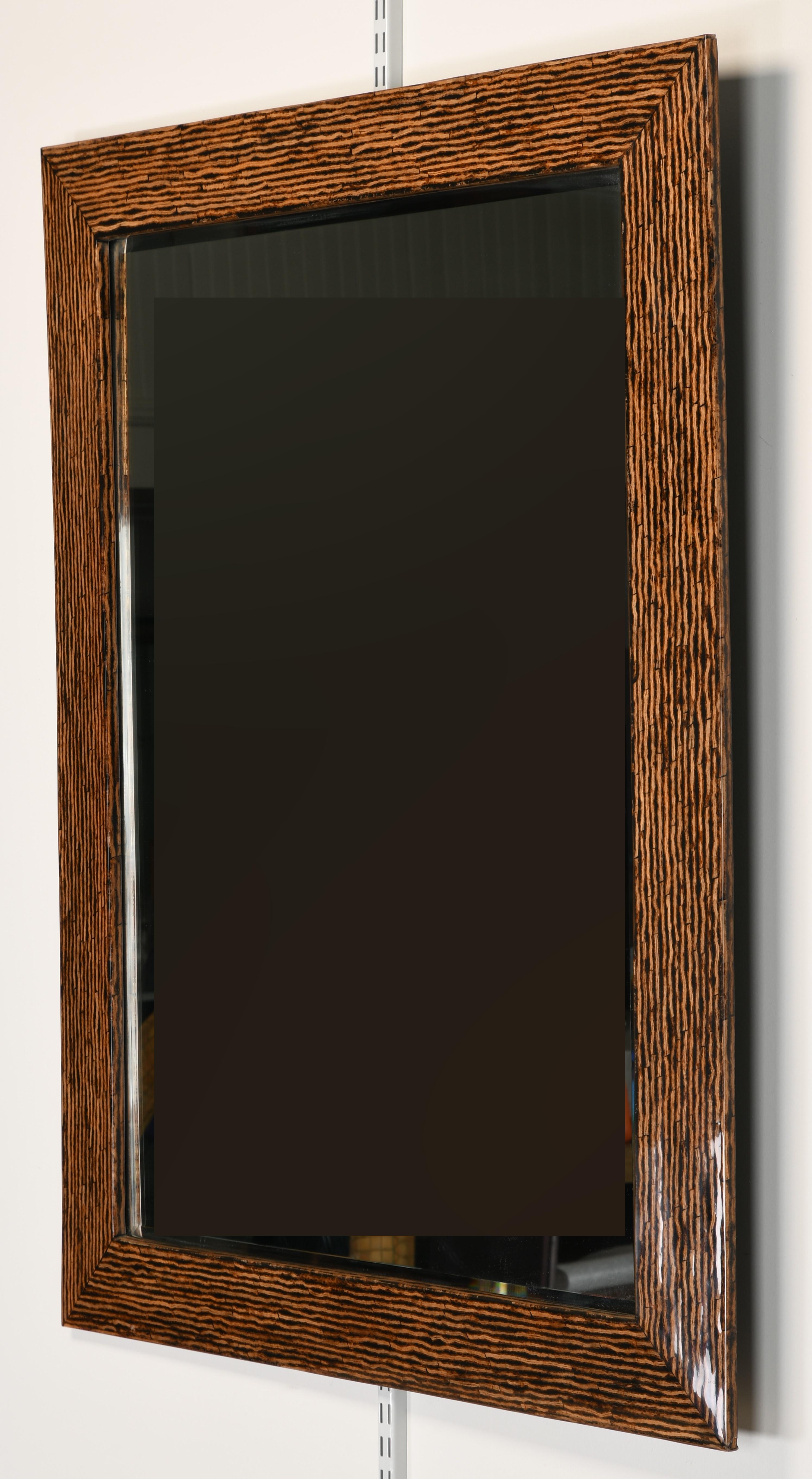 An exotic lacquered Zebra Wood mirror in the manner of Karl Springer. This mirror came out of an interior designer's home which was decorated with Donghia and Kreiss Furniture from the 1980s. Would look great in a traditional or modern setting. Good