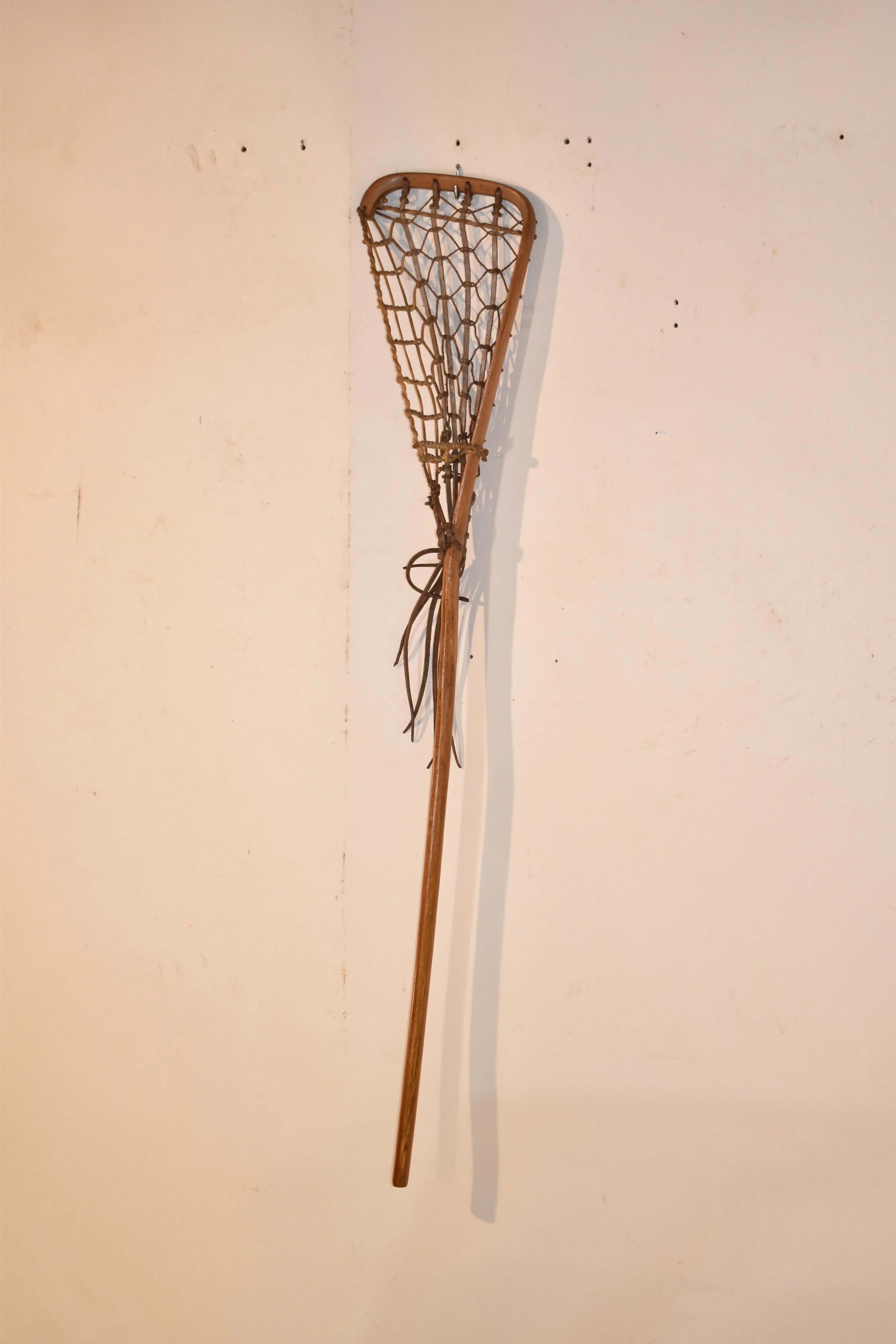 Circa 1920's lacrosse stick made form hickory. The net is woven from leather and twine. This is a beautifully formed bentwood stick that would look great in any room of the house.