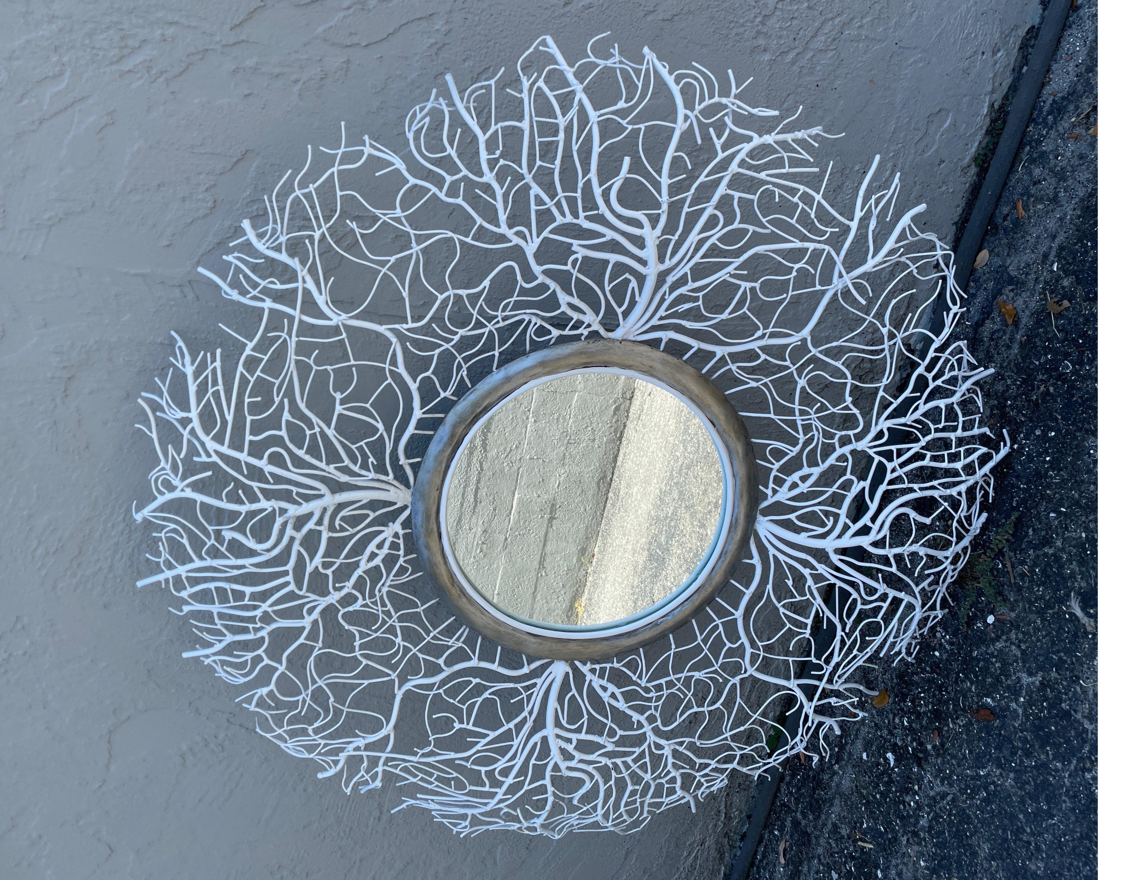 Miroir rond à motif corail en dentelle blanche.