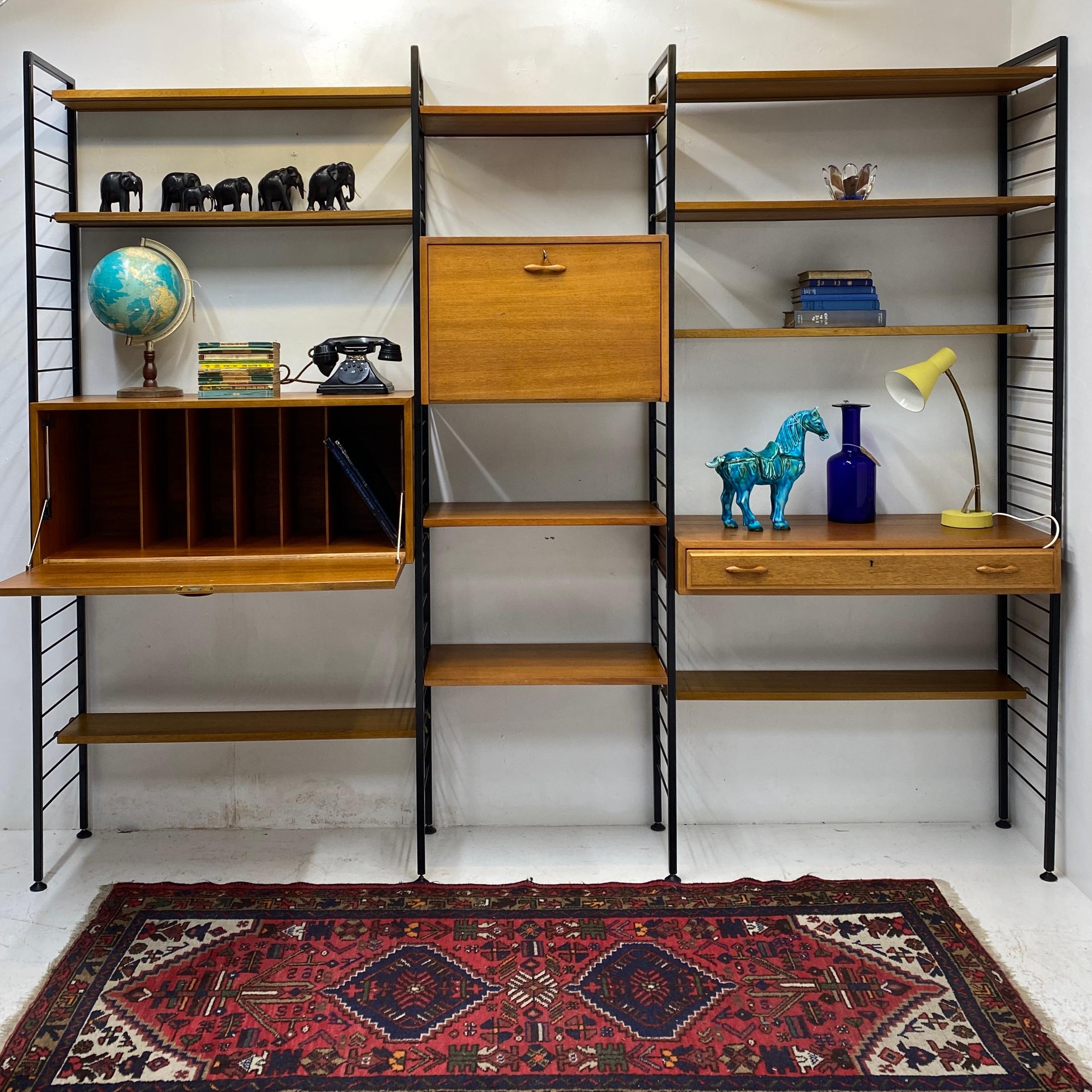 A fabulous vintage ladderax 'staples' system. The ladderax system is made of three bays. The side ladders are in black steel & have both feet on the ground, which makes this system appropriate as a wall unit or a room divider. The ladderax system