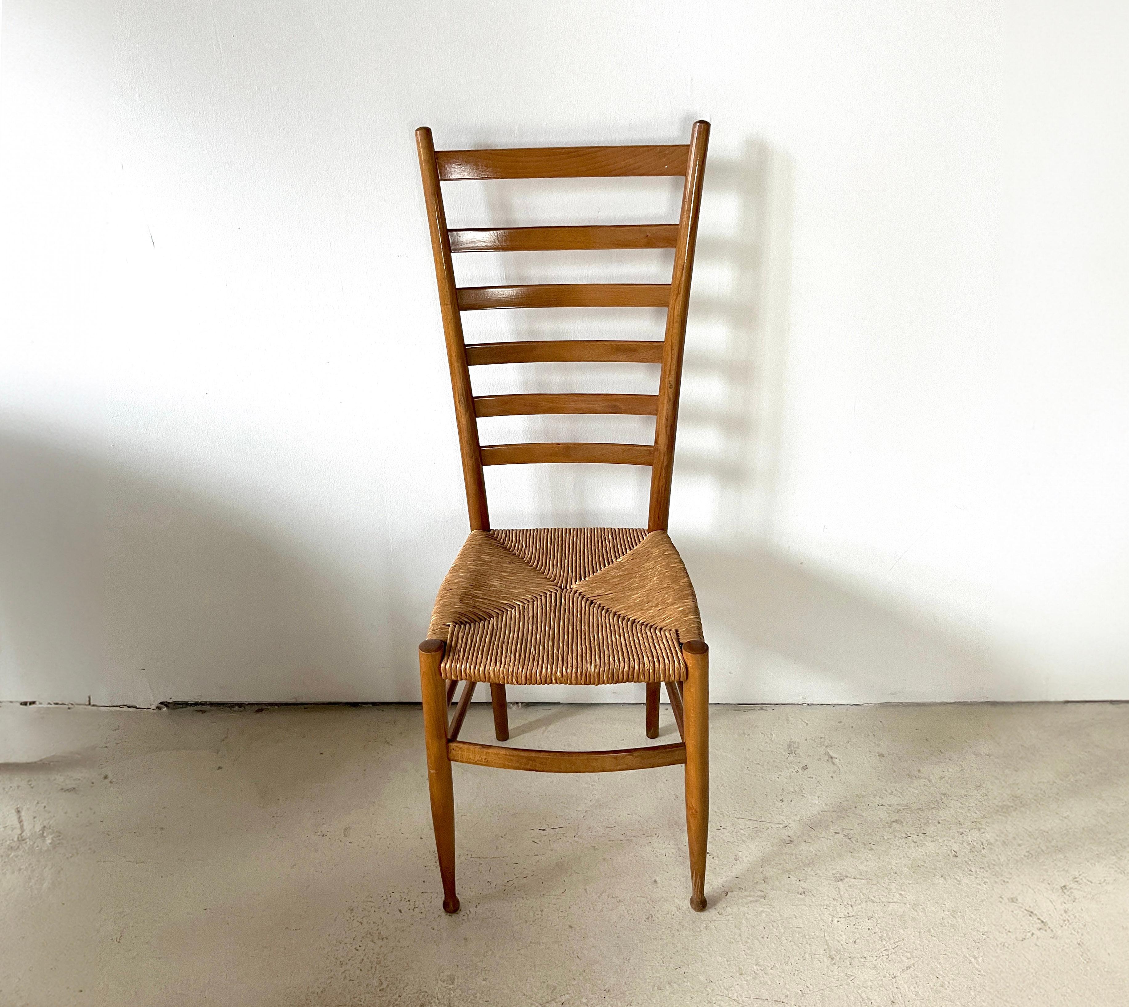 Single elegant Italian dining chair from the 1950s featuring a ladderback wood frame and rush seat. Originally made in Italy, sticker remnants attached to the underside of a stretcher.

Dimensions: 43.5” H x 15” W x 15” D
18.5” seat height

Very