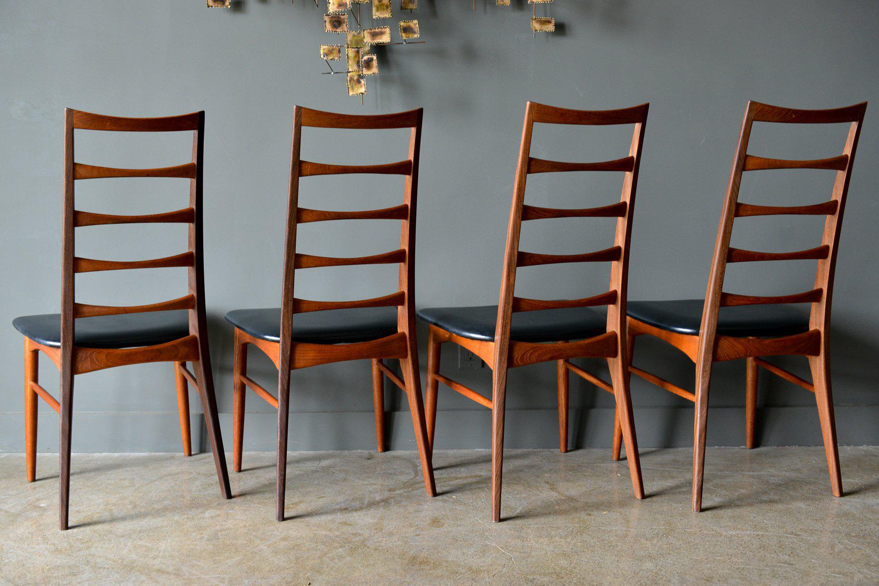 Ladderback Dining Chairs by Niels Kofoed, ca. 1960.  Beautiful original condition with original leatherette seats and sculpted teak ladder backrests.  Teak is dark and has the appearance of walnut so you could pair with any walnut table.  Very good