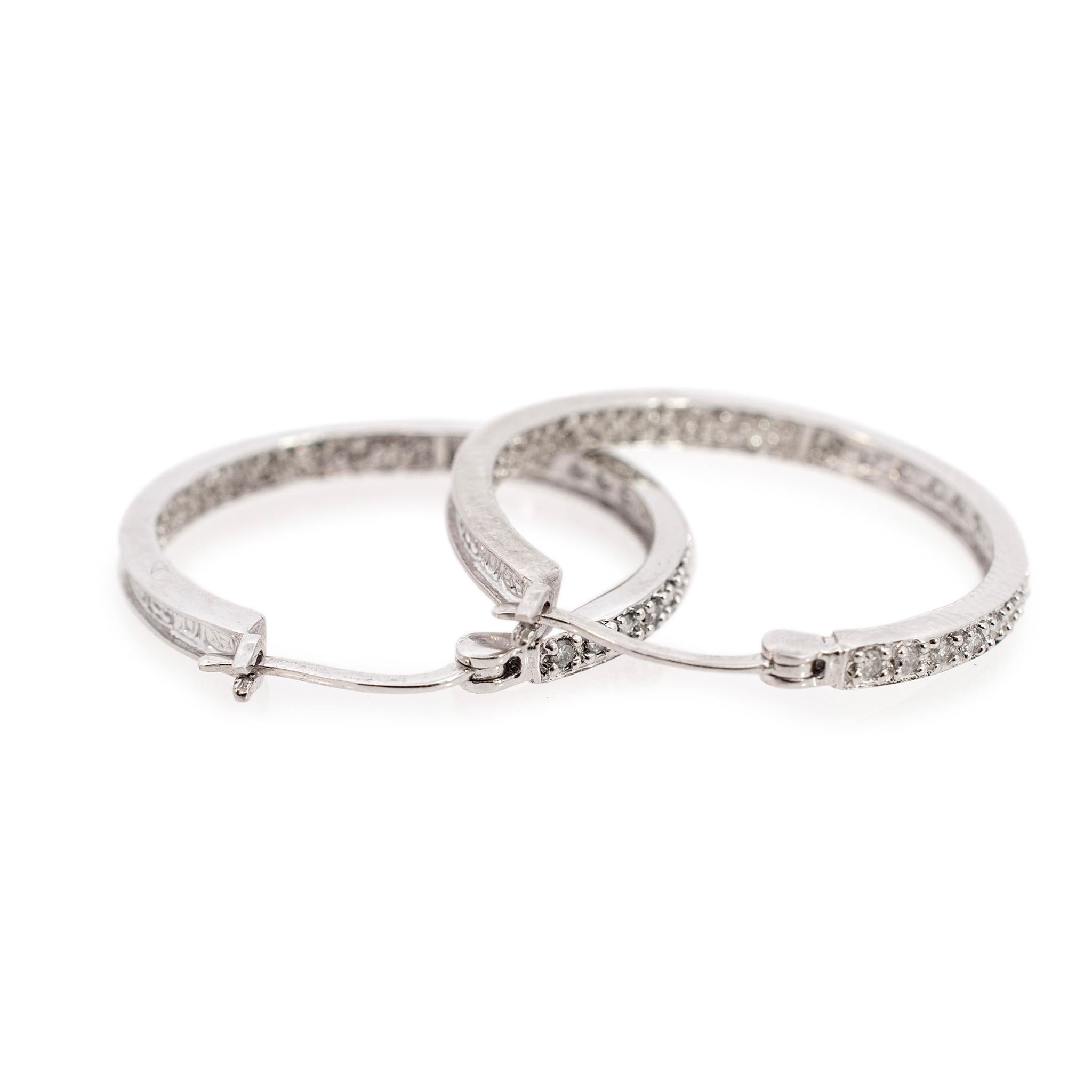 Gender: Ladies

Metal Type: 10K White Gold

Width: 2.50 mm

Diameter: 25.00 mm

Weight: 3.90 grams

One pair of ladies rhodium plated 10K white gold diamond contemporary-style hoop earrings with 