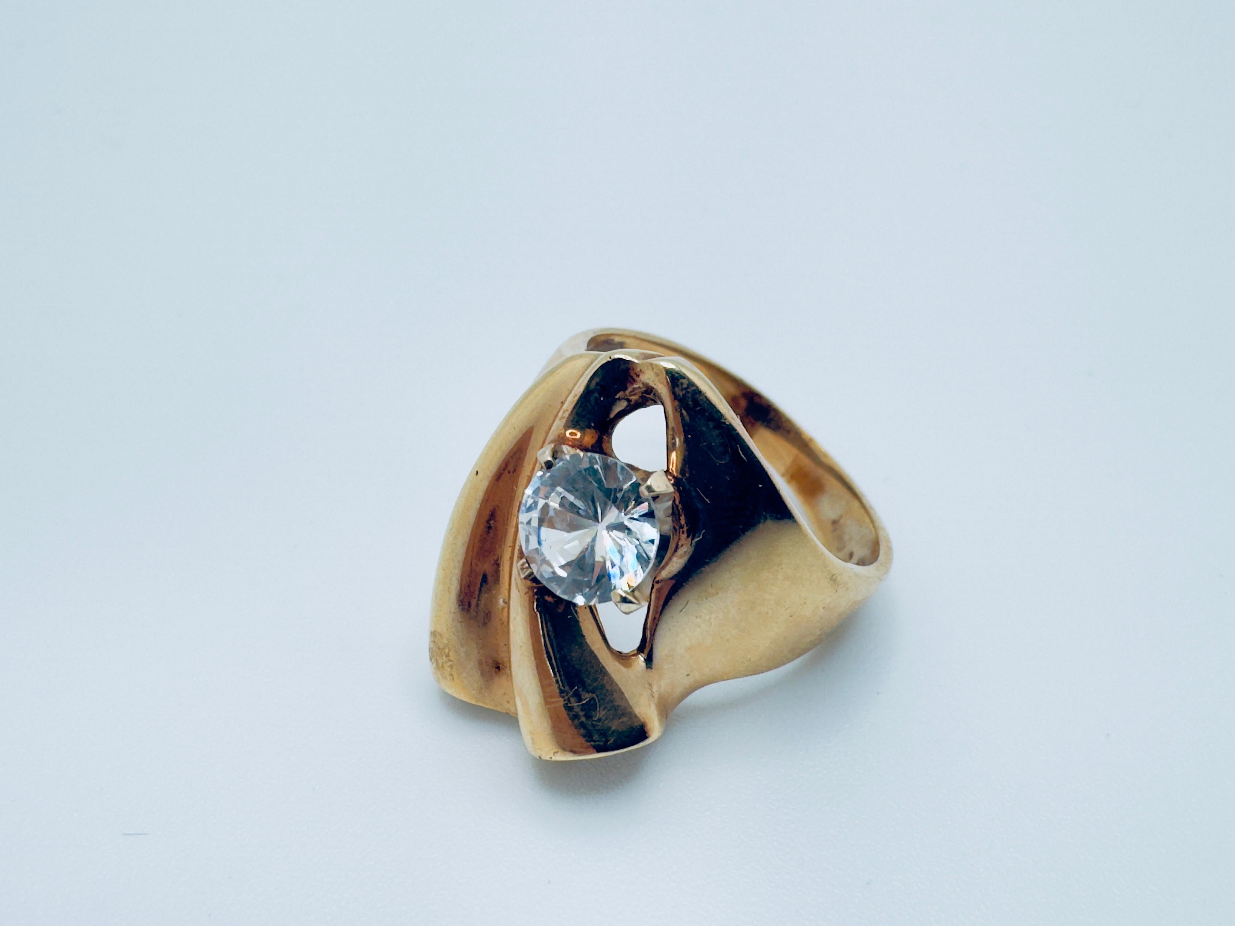 Questo elegante anello da donna è realizzato in oro giallo 14 carati e presenta uno splendido design a forma libera che combina uno stile contemporaneo con una raffinatezza senza tempo. Al centro si trova un'affascinante gemma rotonda di Renzite di