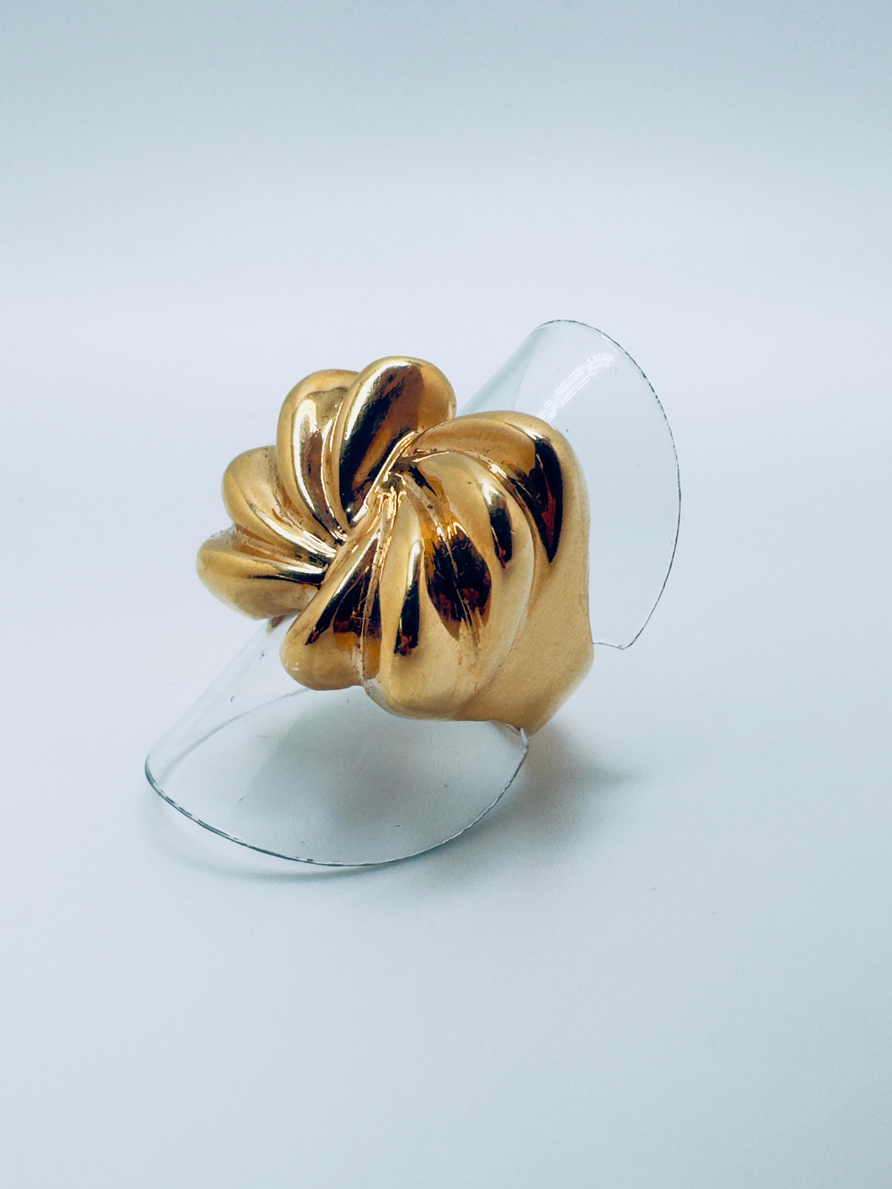 This charming ladies’ ring is crafted in 14-karat yellow gold and features a graceful free-form bow design, blending elegance with playful sophistication. The flowing, asymmetrical curves of the bow create a sense of movement, giving the piece a