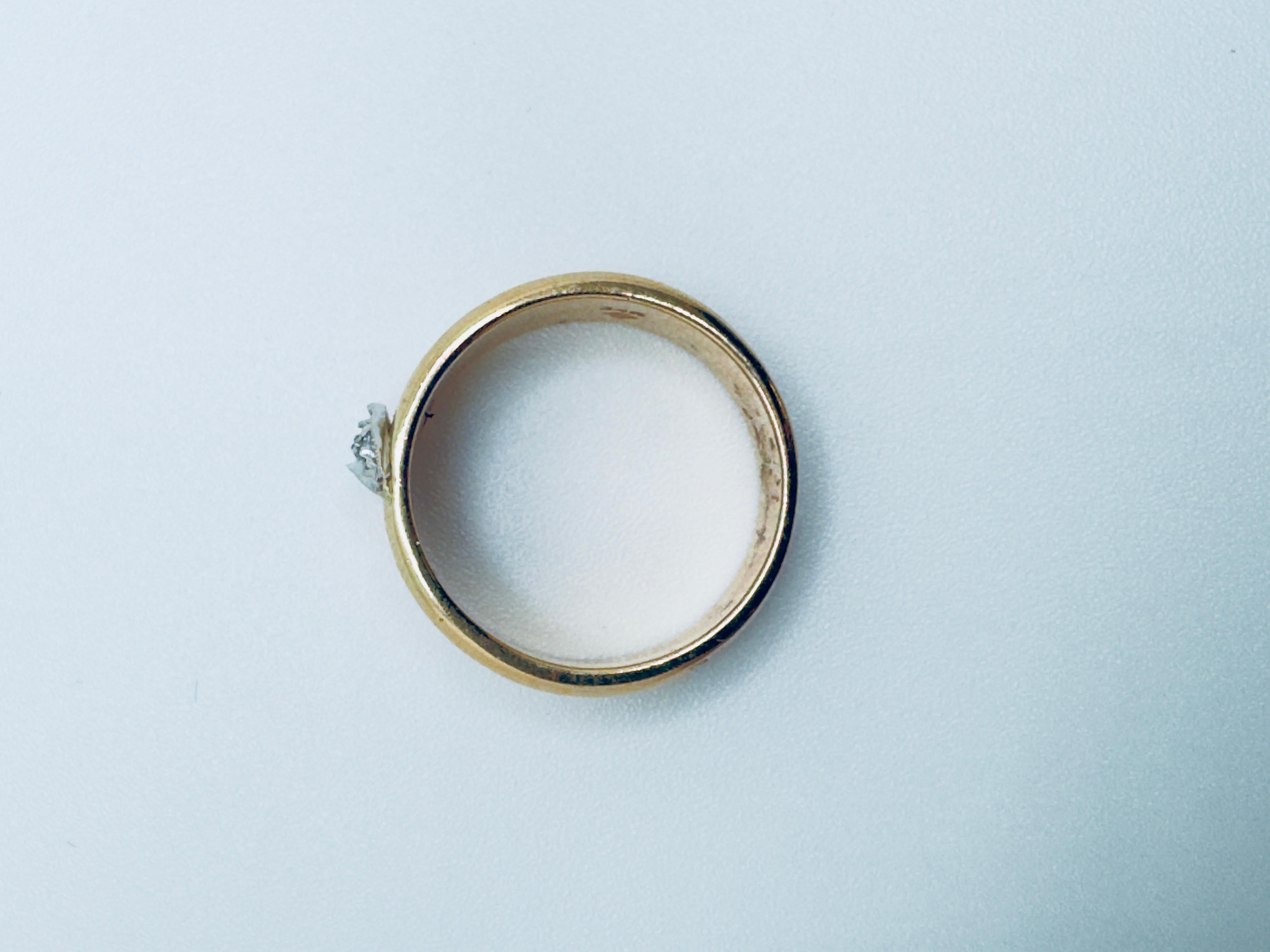 This elegant ladies’ ring is crafted in 14 karat yellow gold with a refined, contemporary design. At its center sits a graceful half-moon-shaped plate in 14 karat white gold, adorned with three round brilliant-cut diamonds totaling approximately
