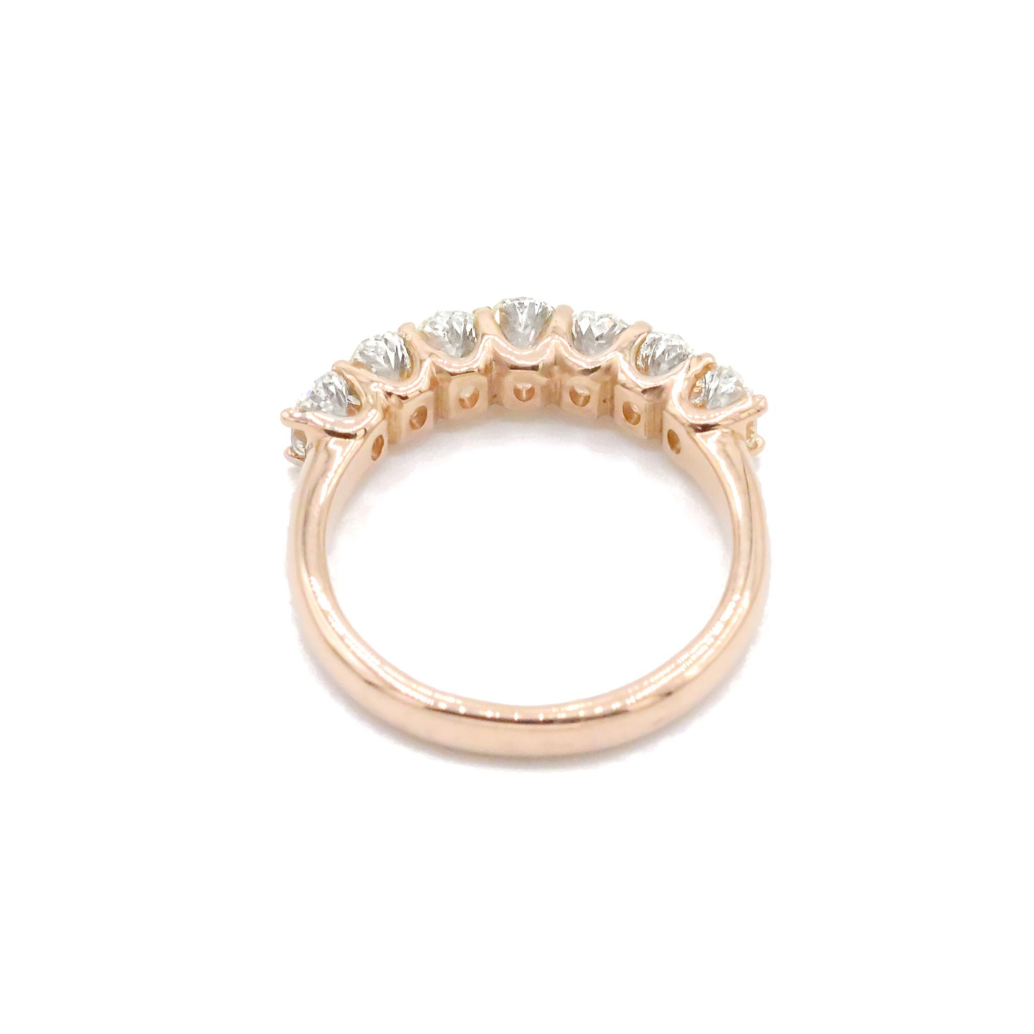 One lady's custom made polished 18K rose gold seven-across, diamond half-eternity ring with a half round shank. The ring is a size 5.5. The ring weighs a total of 4.14 grams. Stamped 