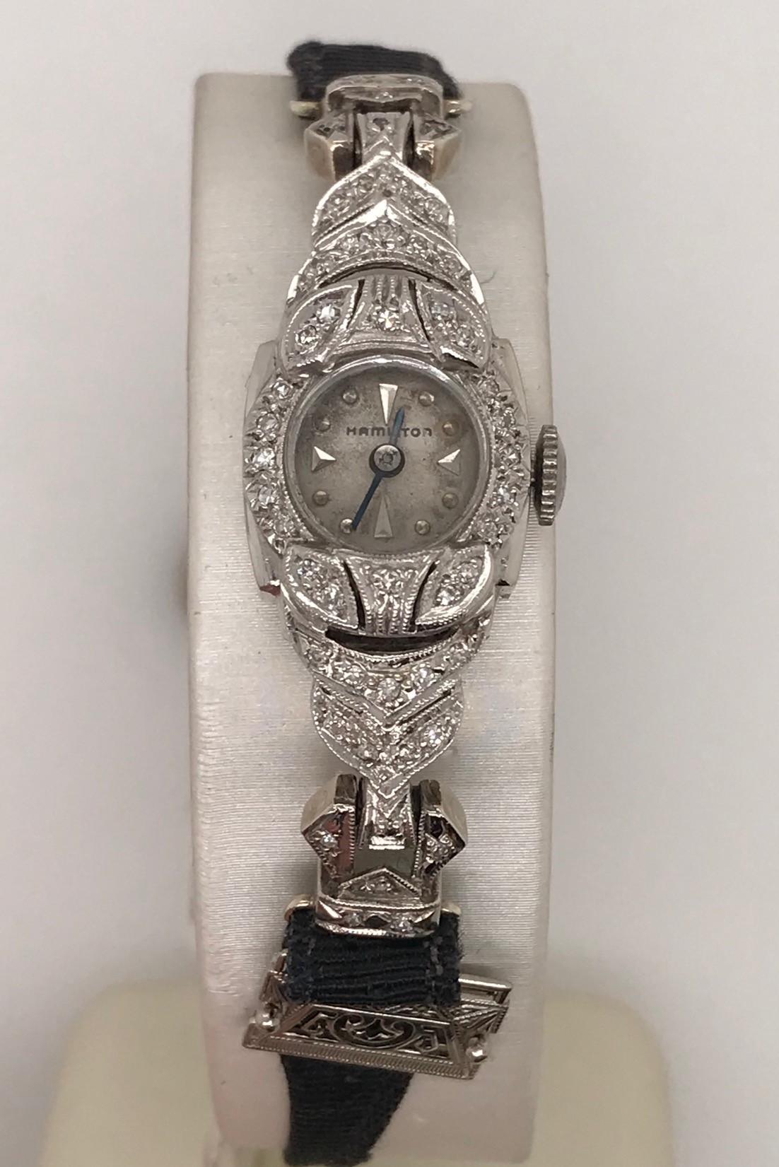 Ladies 14k White Gold Hamilton small wrist watch.  White dial, black grosgrain strap with 50 small diamonds.  This little gem is circa 1940's and will be a beautiful addition to any vintage watch collector. 