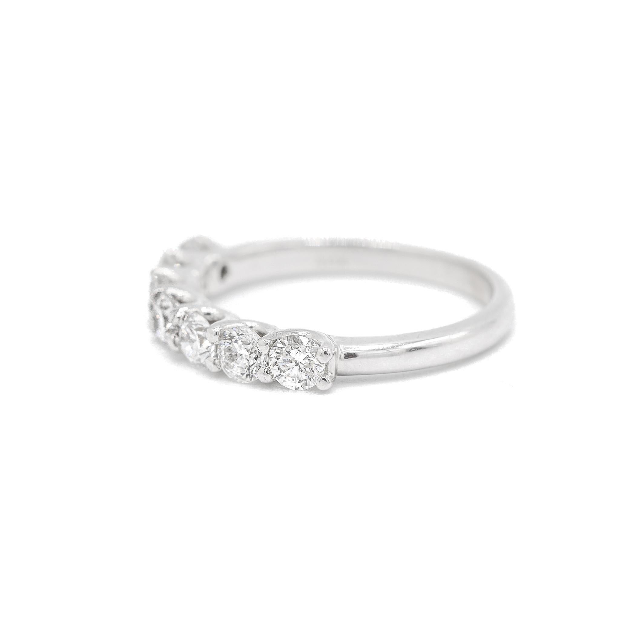 One ladies custom made polished 14K white gold seven-across, diamond half-eternity, wedding ring with a soft-square shank. The ring is a size 6.75, is 1.44mm thick and measures approximately 2.15mm in width and weighs a total of 2.70 grams. Engraved