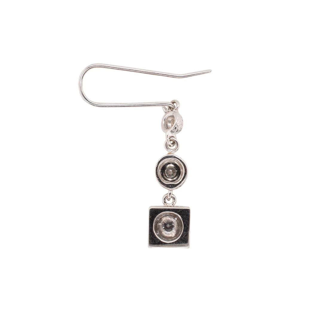 One pair of lady's custom made textured & polished rhodium plated 14K white gold, diamond vintage, dangle earrings with omega-wire backs. The earrings measure approximately 1.75 inches in length by 7.26mm in diameter and weigh a total of 6.60 grams.