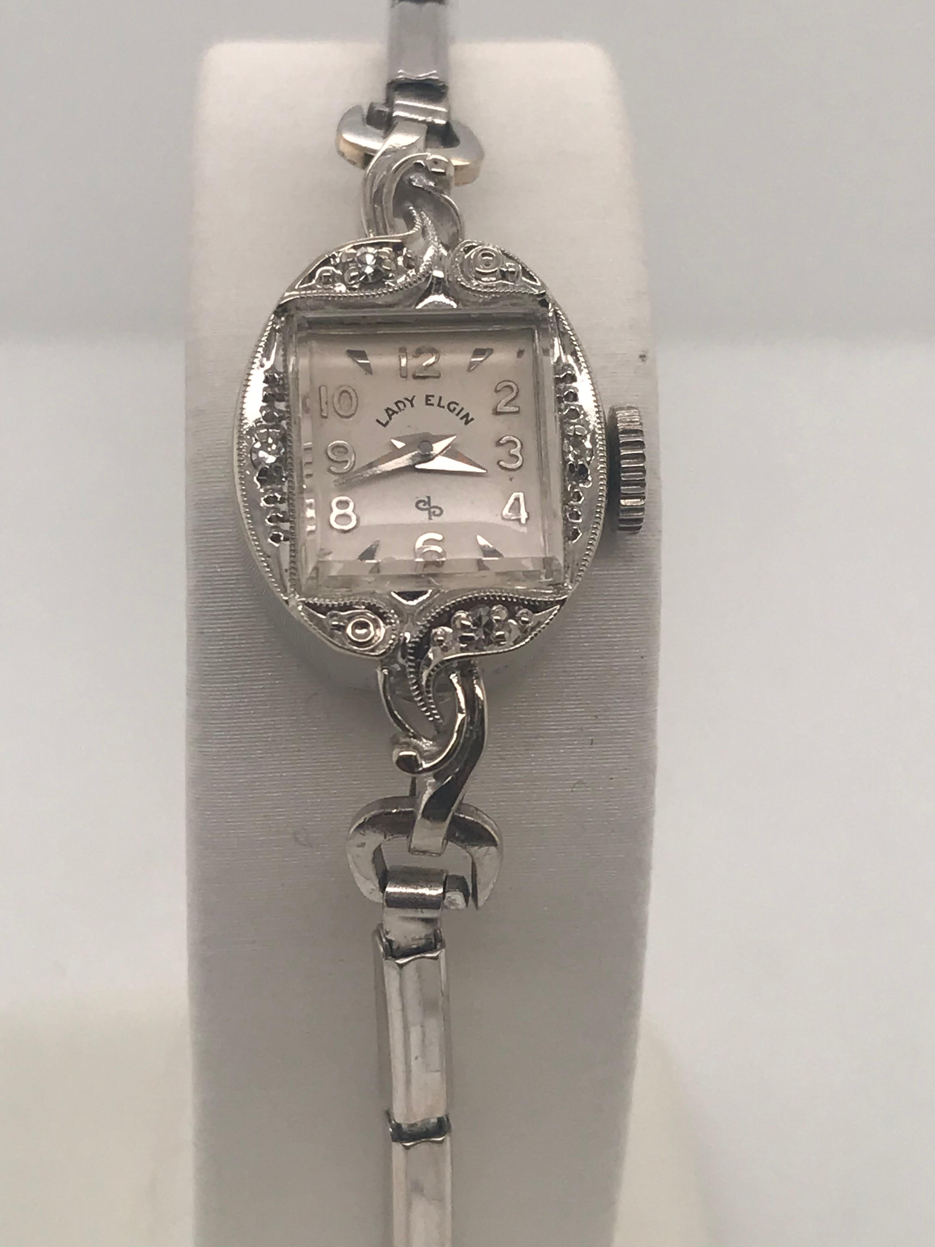 This is a very dainty 14 Karat white gold Lord Elgin Timepiece.  The date goes back to the 1960's, it has a 17 jewel movement with four single cut diamonds with a total weight of .02cts with an attached white gold filled stretch band.  The timepiece