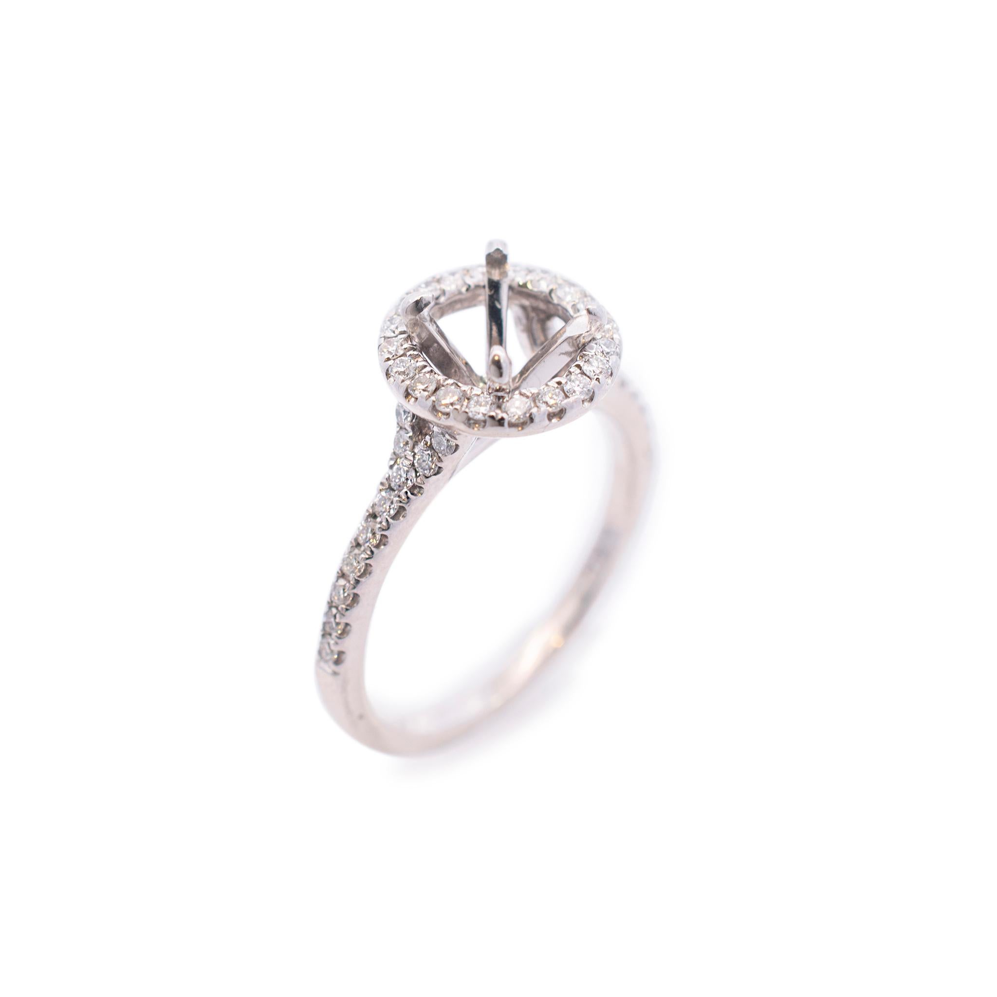One ladies custom made polished rhodium plated 14K white gold, diamond engagement, halo, semi-mount ring with a half round shank. The ring is a size 6.25, is 1.60mm thick and measures approximately 10.26mm tapering to 10.16mm in width and weighs a