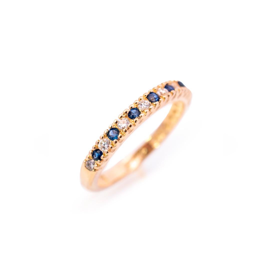 Gender: Ladies

Metal Type: 14K Yellow Gold

Size (US): 6

Shank Width: 2.40mm

Weight: 2.44 grams

Ladies 14K yellow gold diamond and sapphire wedding band with a half-round shank. Engraved with 