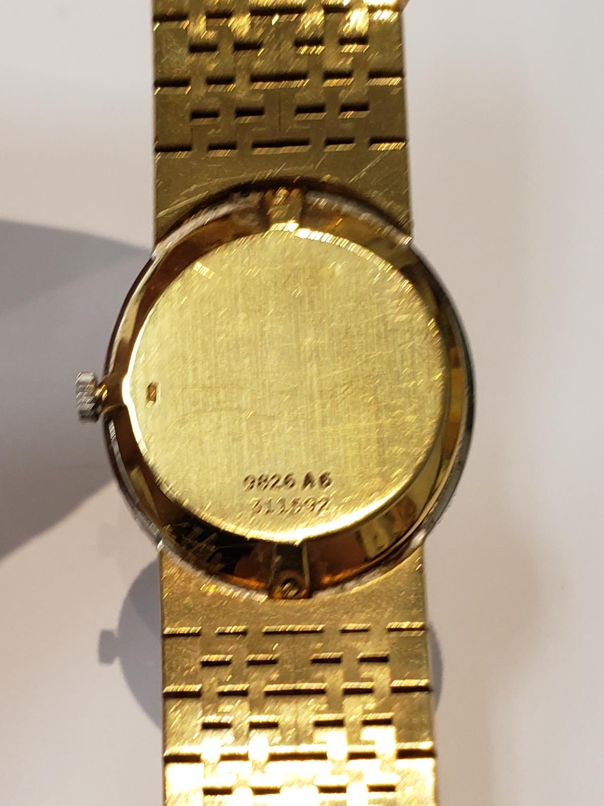 Circa 1980 ladies 18 karat yellow gold Piaget watch with an oval lapis dial. Watch has a diamond bezel and markers, on a textured integrated bracelet. Watch has a manual wind movement. Swiss made. Diamond weight is 1 carat. case is stamped 9826 A6