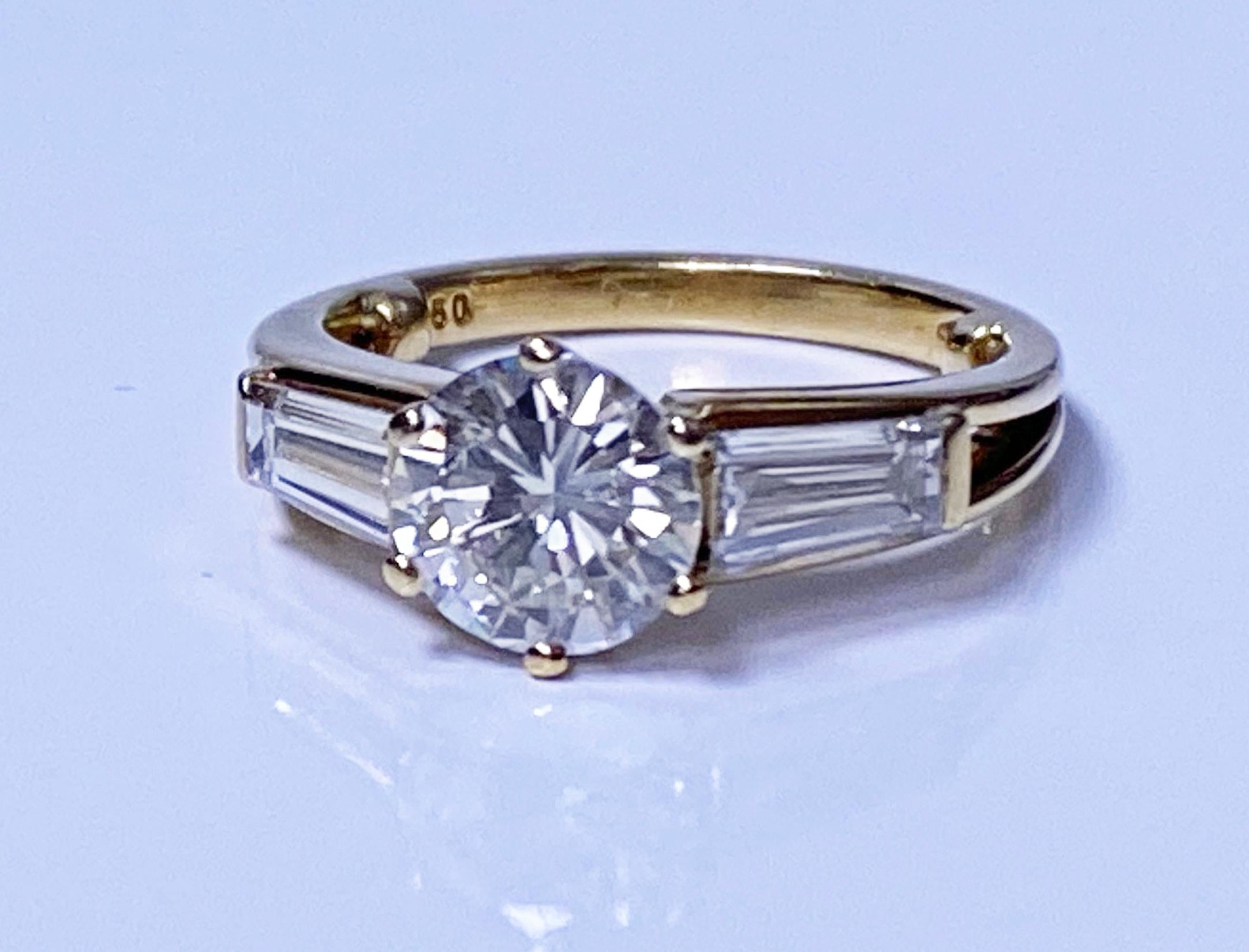 Ladies 18K yellow gold Diamond Ring. The ring set with a round brilliant cut Diamond gauging approximately 6.80 x 6.70 x 3.80 mm, weight 1.06 cts, VS1 clarity, I colour, flanked on either side with a tapered baguette cut diamond, each approximately