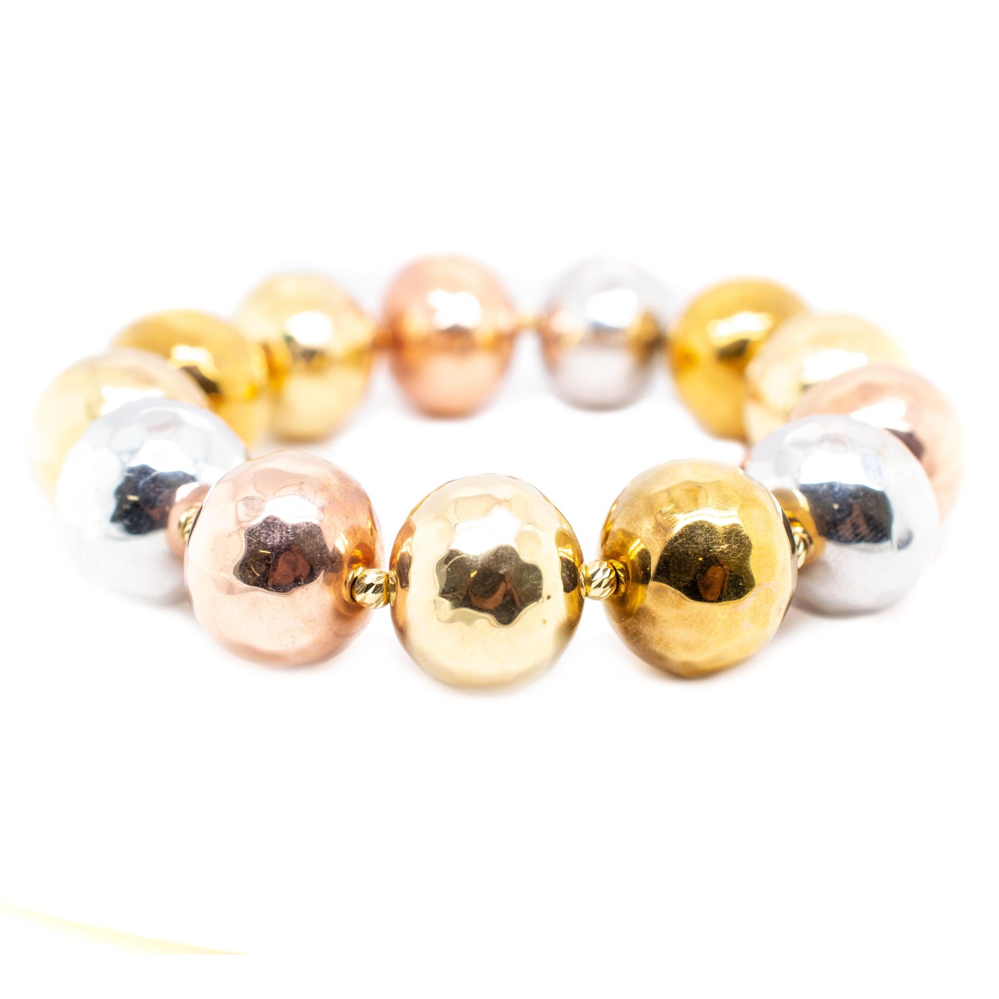One lady's custom made polished 18K tri-color gold, bead bracelet. The bracelet measures approximately 6.50 inches in length by 16.50mm in diameter and weighs a total of 19.20 grams. In excellent condition.

SKU: 138865