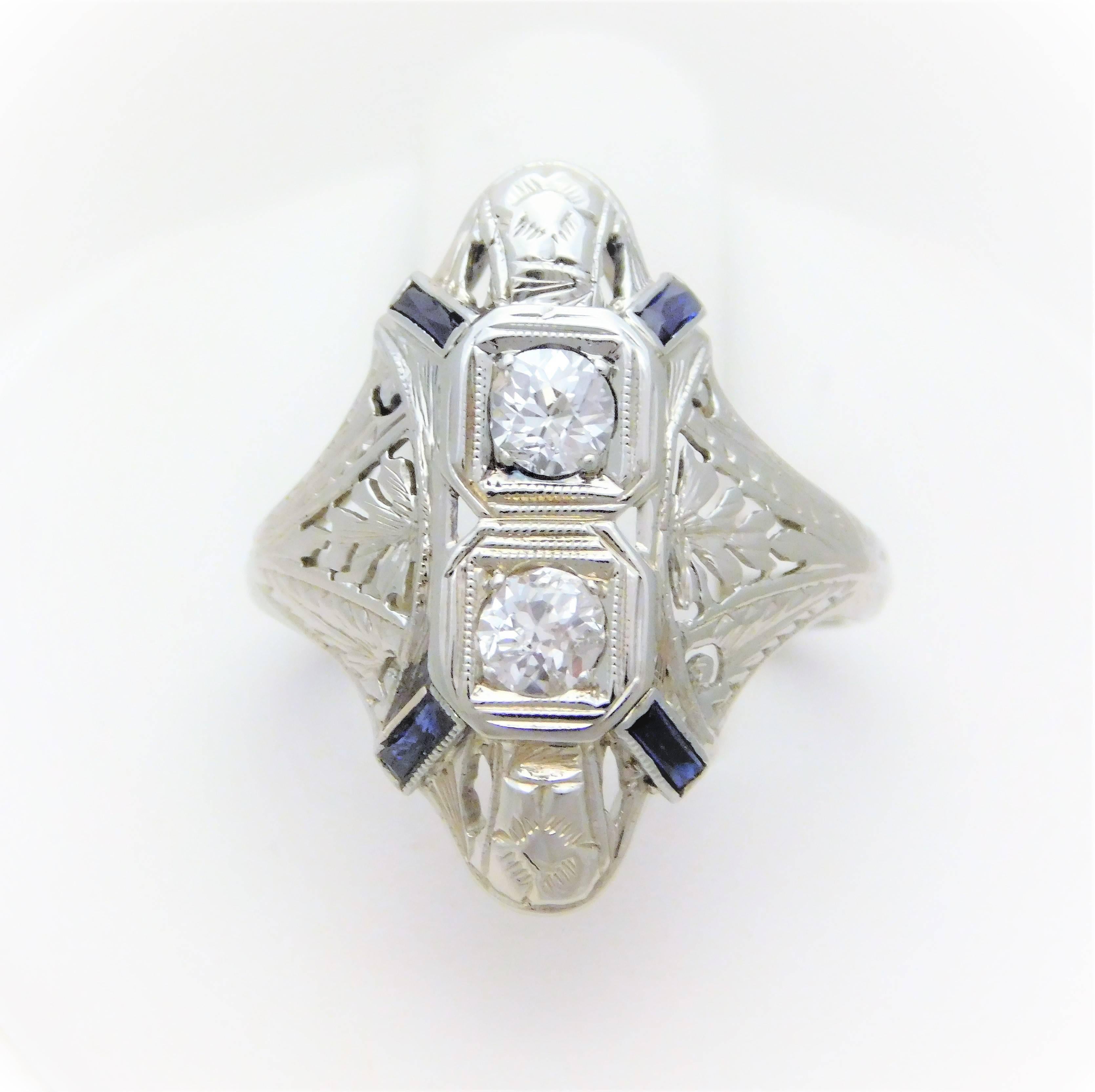 From a lovely New Orleans estate. Circa Early 20th Century. The shield ring design was one of the most popular designs from 1900-1930. This beautiful example has been hand crafted in solid 18k white gold. It has been masterfully jeweled with two Old