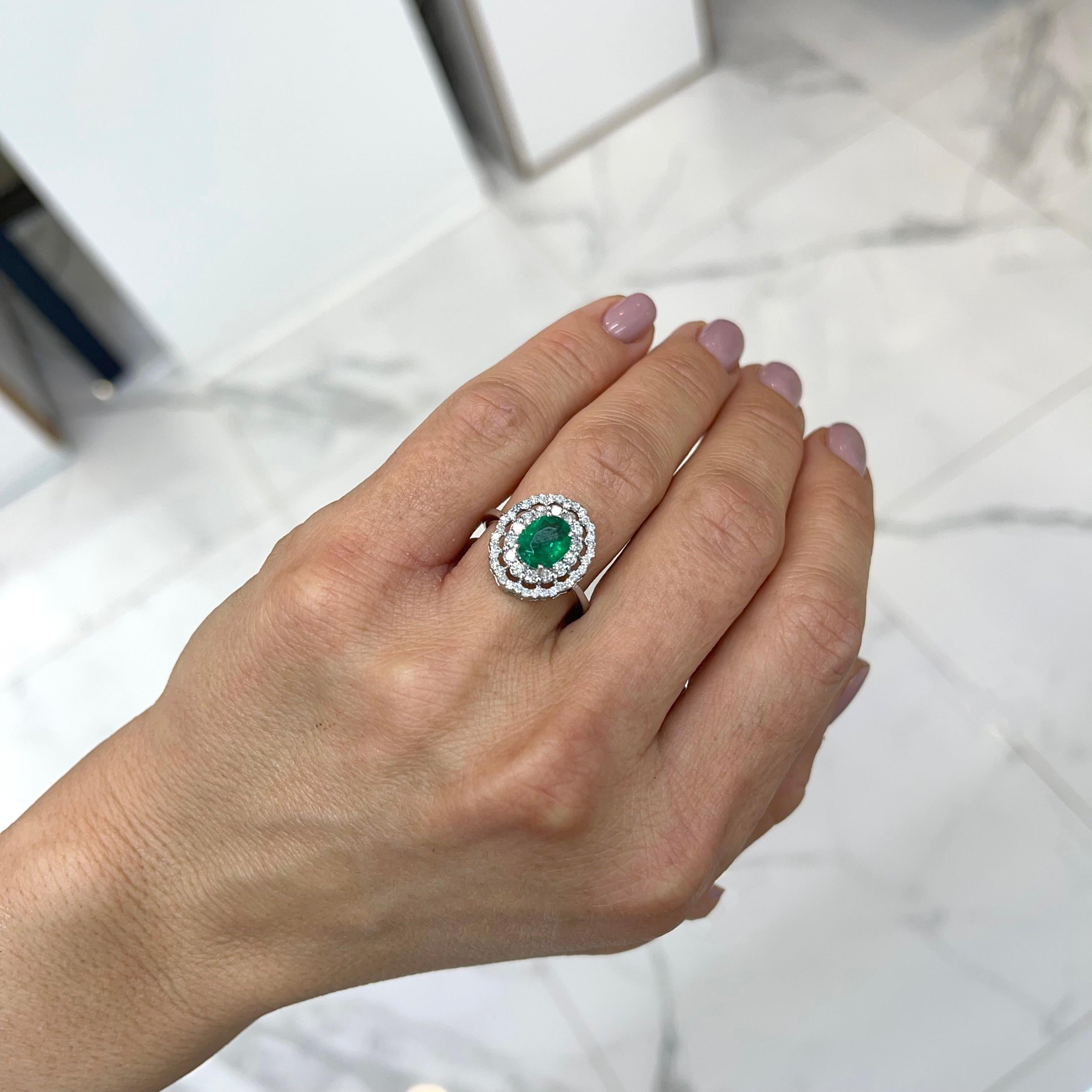 Contemporary Ladies 18k White Gold Oval Emerald Halo Diamond Cocktail Ring For Sale