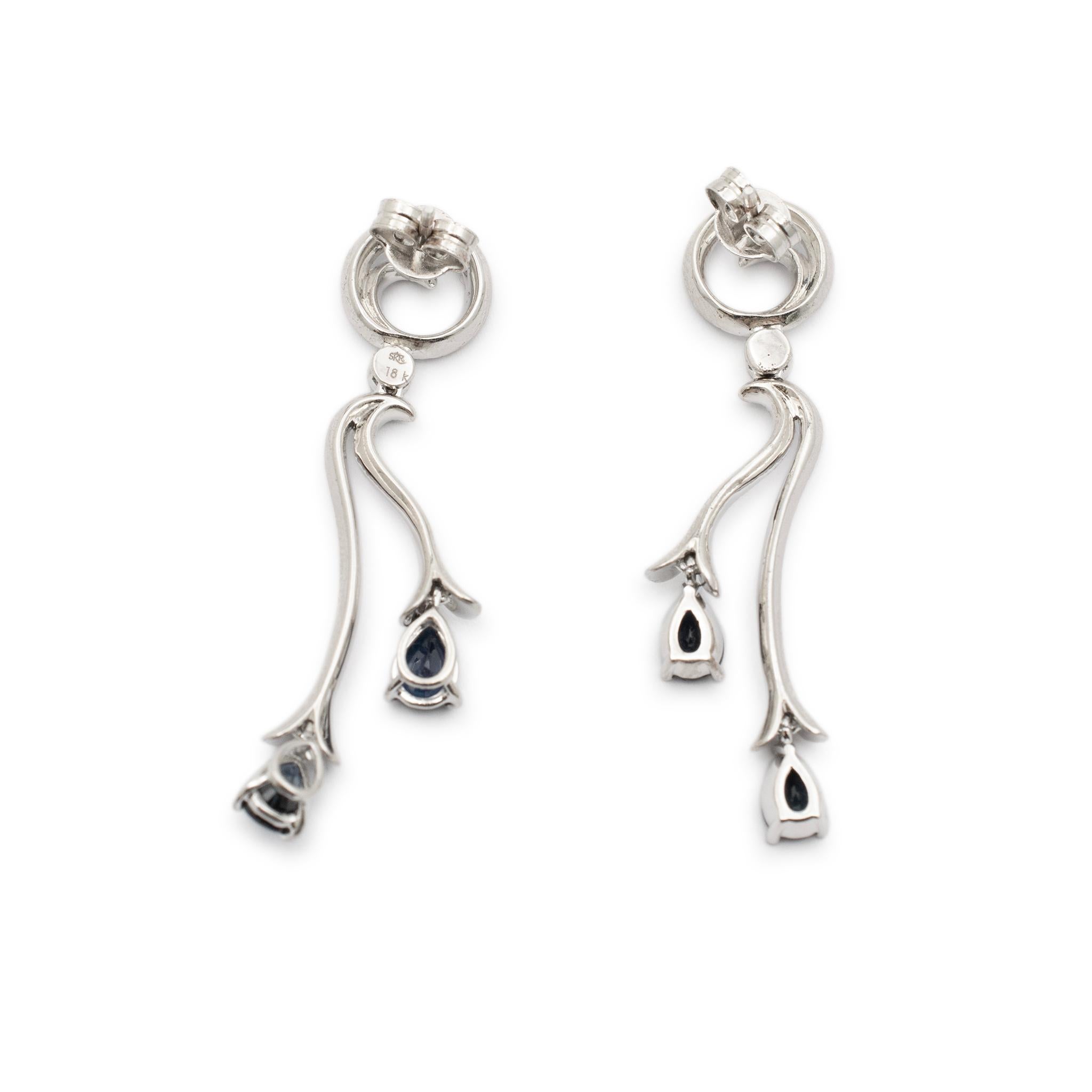 Gender: Ladies

Metal Type: 18K White Gold

Length: 1.75 Inches

Width: 10.10 mm

Weight: 7.90 grams

Ladies rhodium plated 18K white gold diamond and sapphire dangle drop earrings with push backs. Stamped 