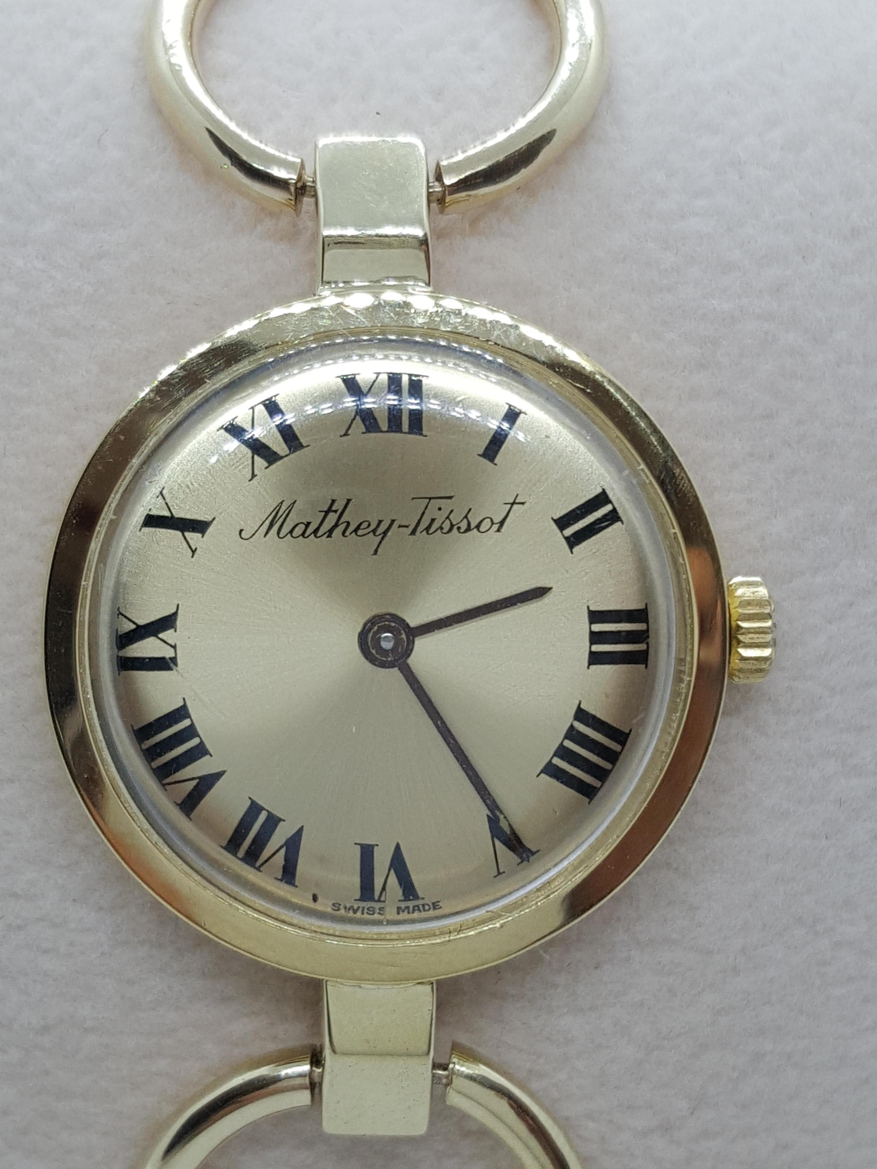 Beautiful ladies 18kt yellow gold Mathey-Tissot watch with a 25mm case (7mm thick), gold face with black Roman numerals, manual wind, and Swiss-made (note: the case is 18kt yellow gold and the bracelet is 14kt yellow gold). The style number for this