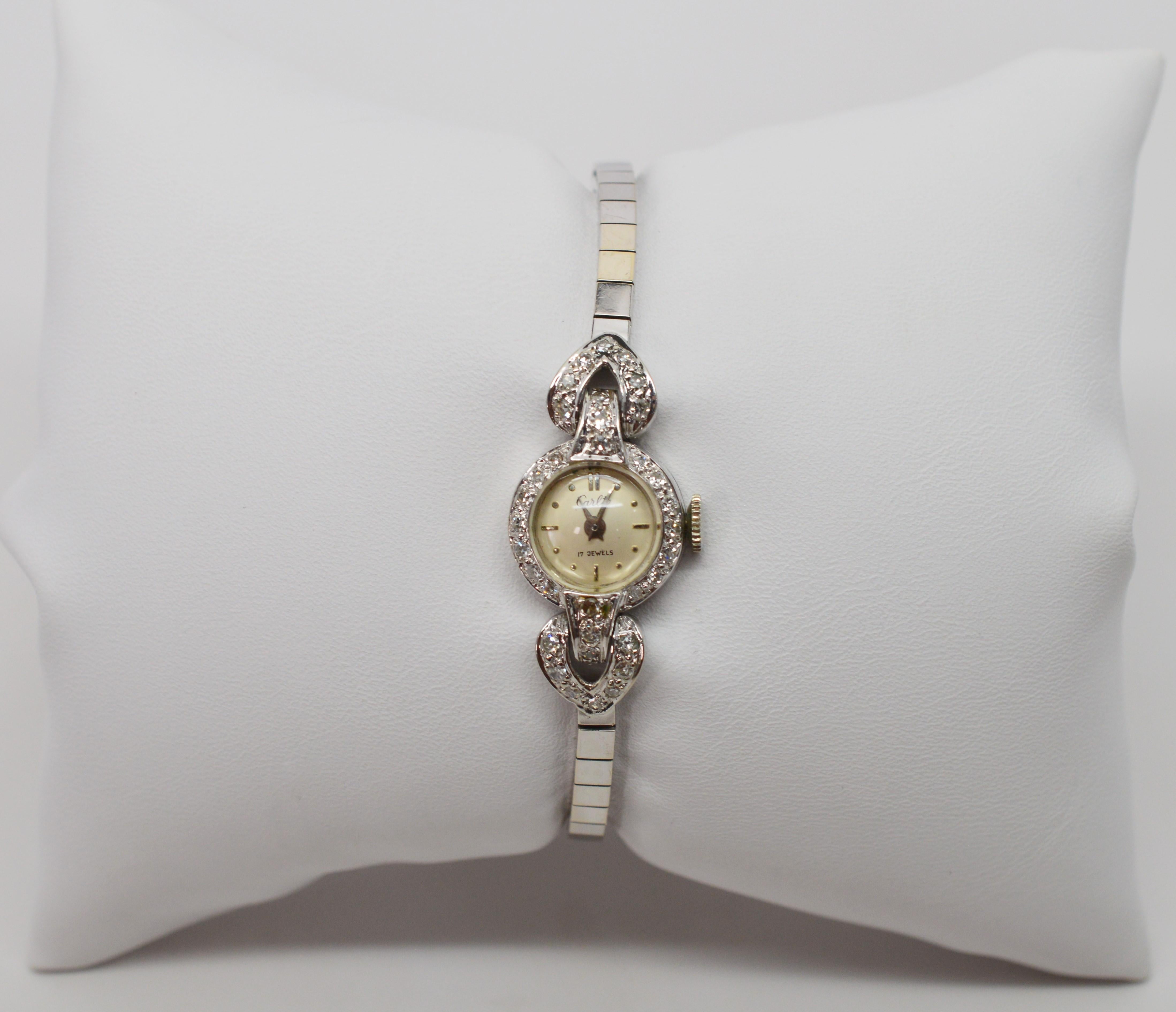 Fine and feminine in fourteen carat white gold, this women's diamond enhanced antique bracelet watch by Carloto is exquisite. 
Thirty six H/I1 diamonds, totaling one third carat total weight adorned it's petite round face and heart-shaped side