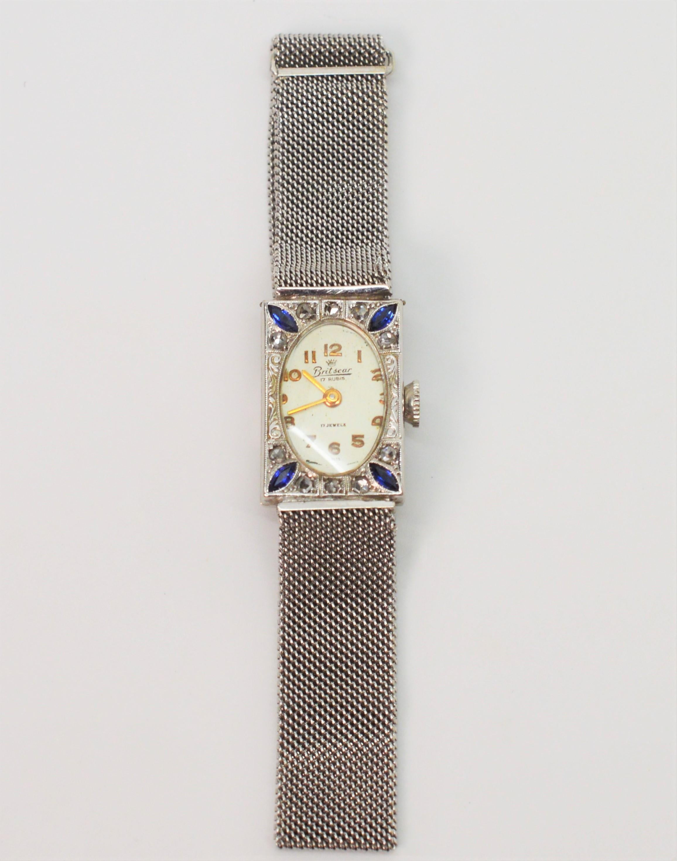 With antique allure, this beautiful ladies art deco Britscar wrist watch, circa 1930's, has a working Swiss 17 jeweled movement. The eighteen karat white gold rectangular watch face measuring approximately 24mm x 26mm is enhanced with ten rose cut