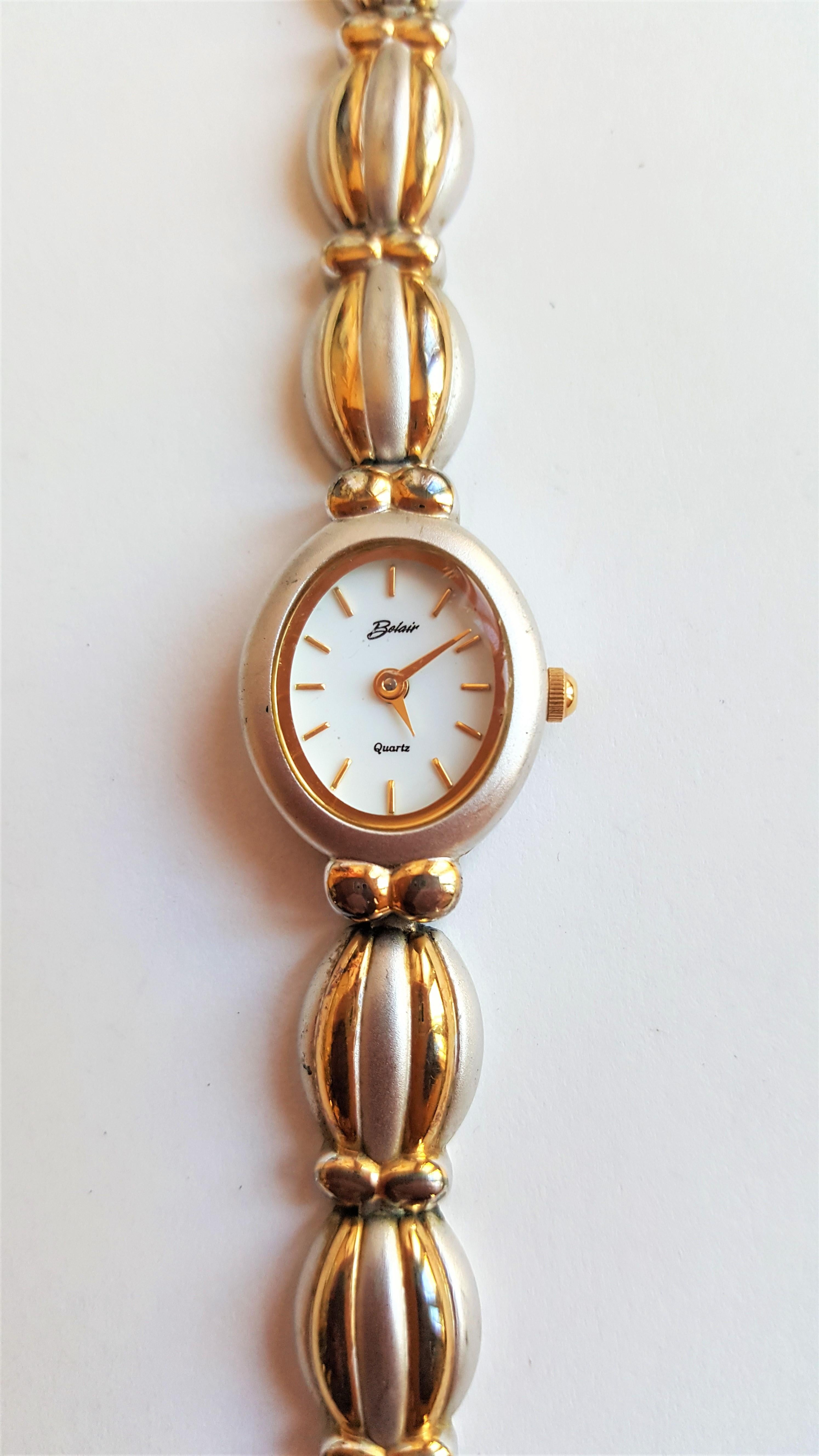 Lovely ladies stainless steel and gold plated Belair watch with a very nice scalloped design. The total length of the watch(with the extra links) is 7 inches and without the links is 6 inches. Made in USA with Swiss parts. The oval case is 21mm x