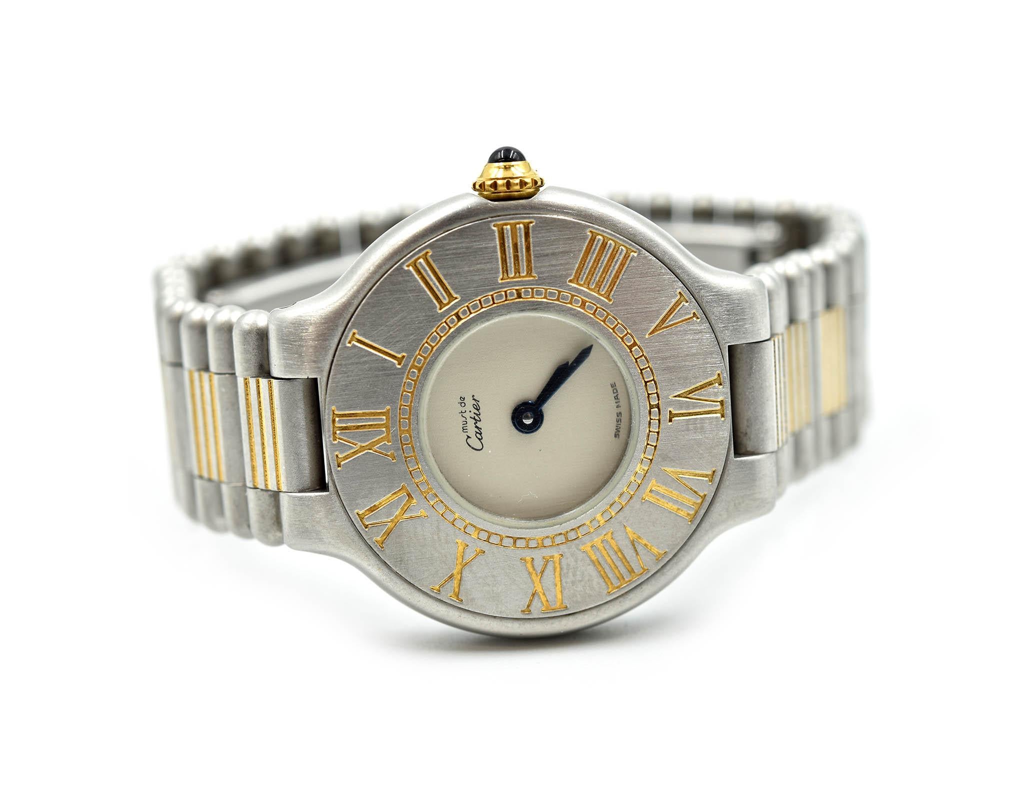 Movement: quartz
Function: hours, minutes
Case: round 28mm stainless steel case with gold tone accent case with blue sapphire cabochon crown
Band: Cartier stainless steel and gold tone bullet bracelet, fit for 5 ½ inch wrist  
Dial: Cartier satin