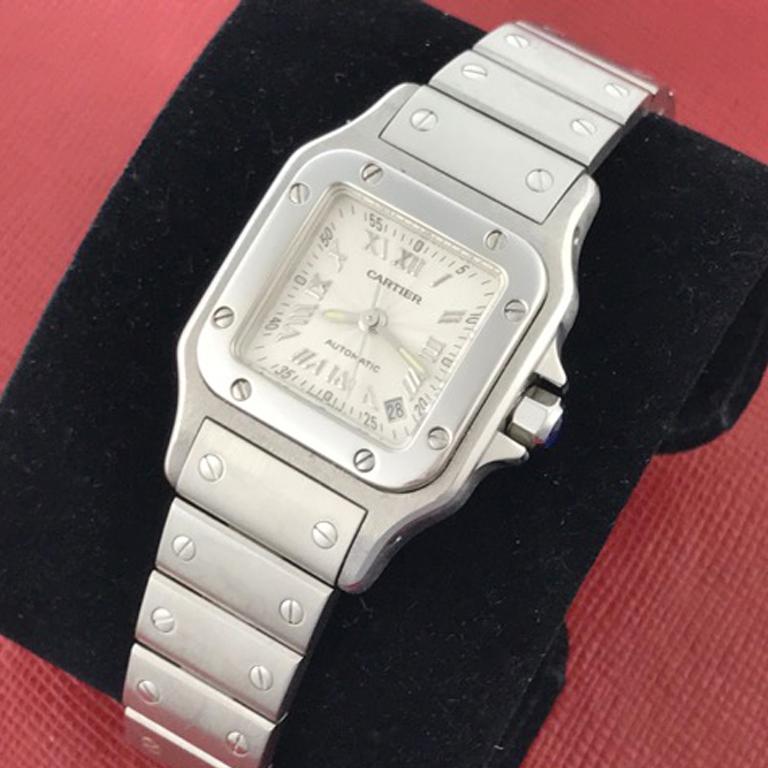 Cartier Ladies Santos Model W20054D6 Stainless Steel Wrist Watch. Quartz movement. Stainless Steel square style case with blue sapphire cabachon setting crown (24x34mm). Water Resistant to 30 Meters - 100 Feet. Stainless Steel bracelet with