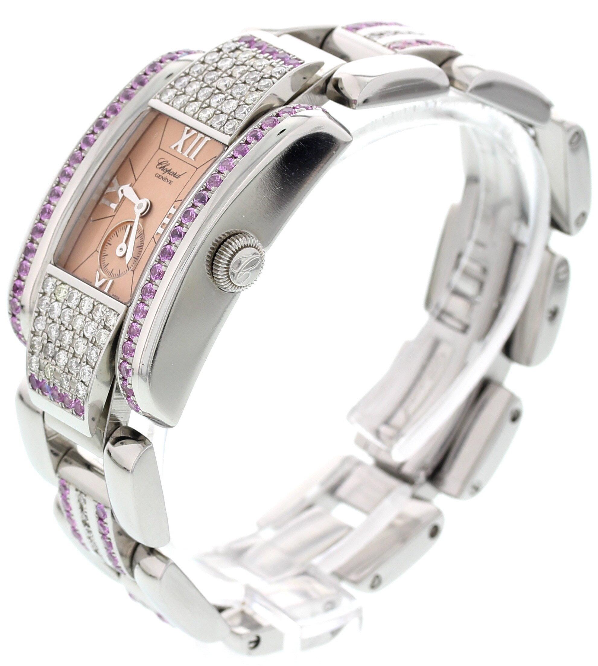 Ladies Chopard La Strada watch. 24 mm stainless steel case with custom set diamonds and pink colored stones.  Pink dial with second sub-dial and roman markers. Stainless steel band with custom set diamonds and a hidden double folding clasp; will fit