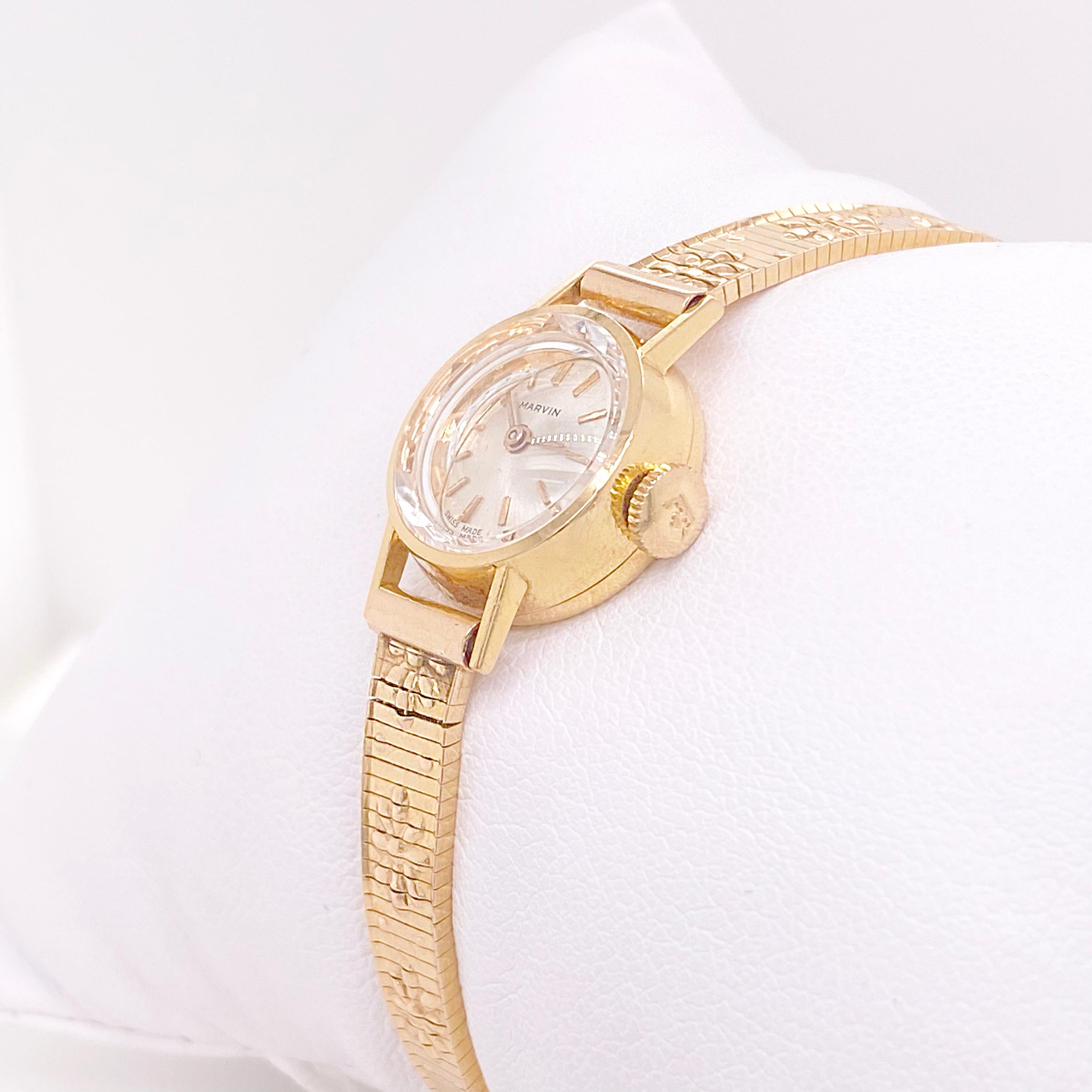 Ladies 14k yellow gold Marvin Watch-so feminine and rare! The small gold watch is the perfect addition is a delicate wrist with a gorgeous silver dial with 14 karat gold markers. The crystal has some gorgeous diamond cutting on it that makes it