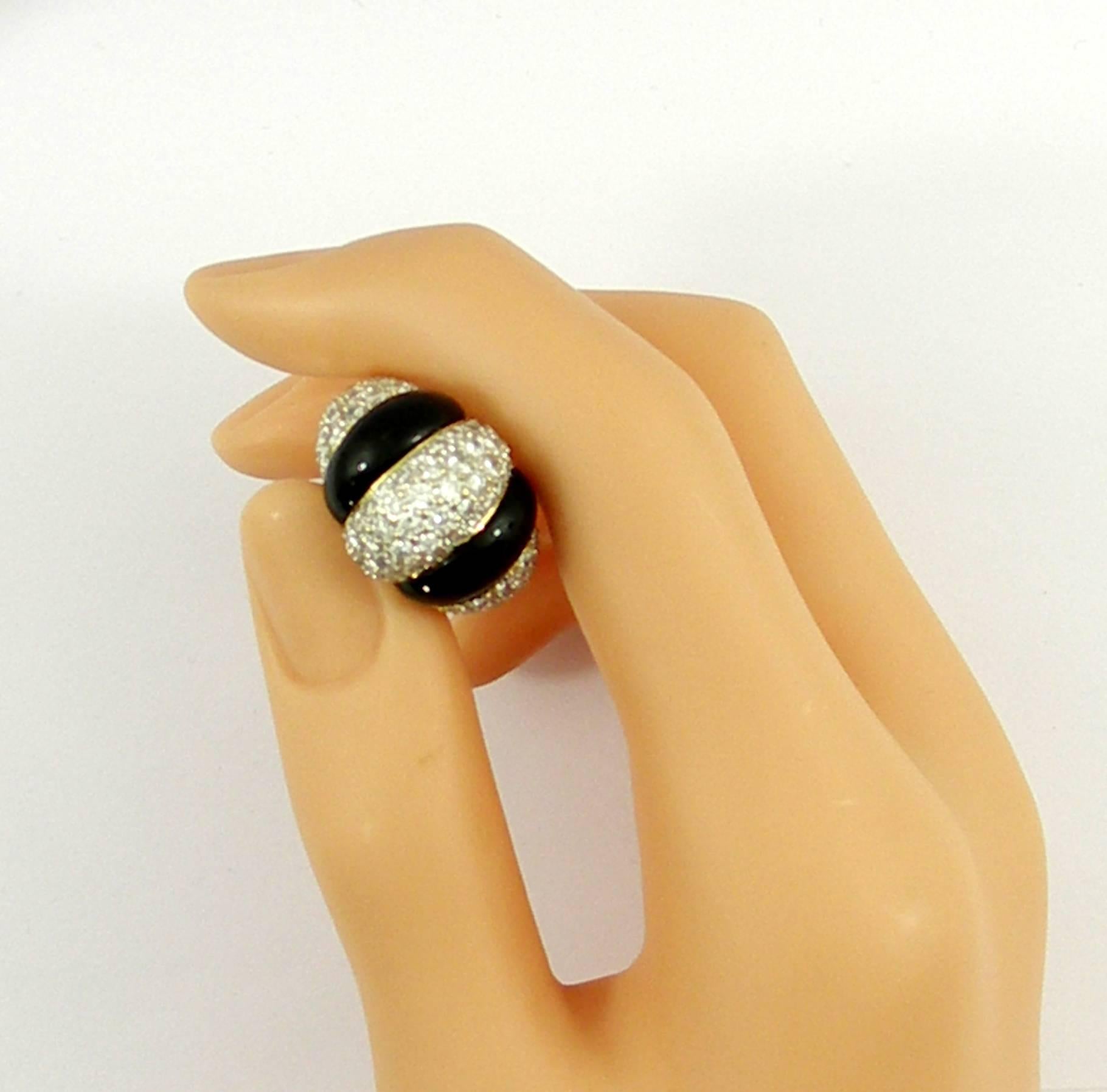One ladies 18 karat yellow gold ring measuring 5/8 of an inch wide with three pave diamond sections and two onyx stripes. Overall diamond weight is approximately 3.4 ct, and diamonds are of F/G color and VS1 clarity. Ring is a size 7 1/4, and