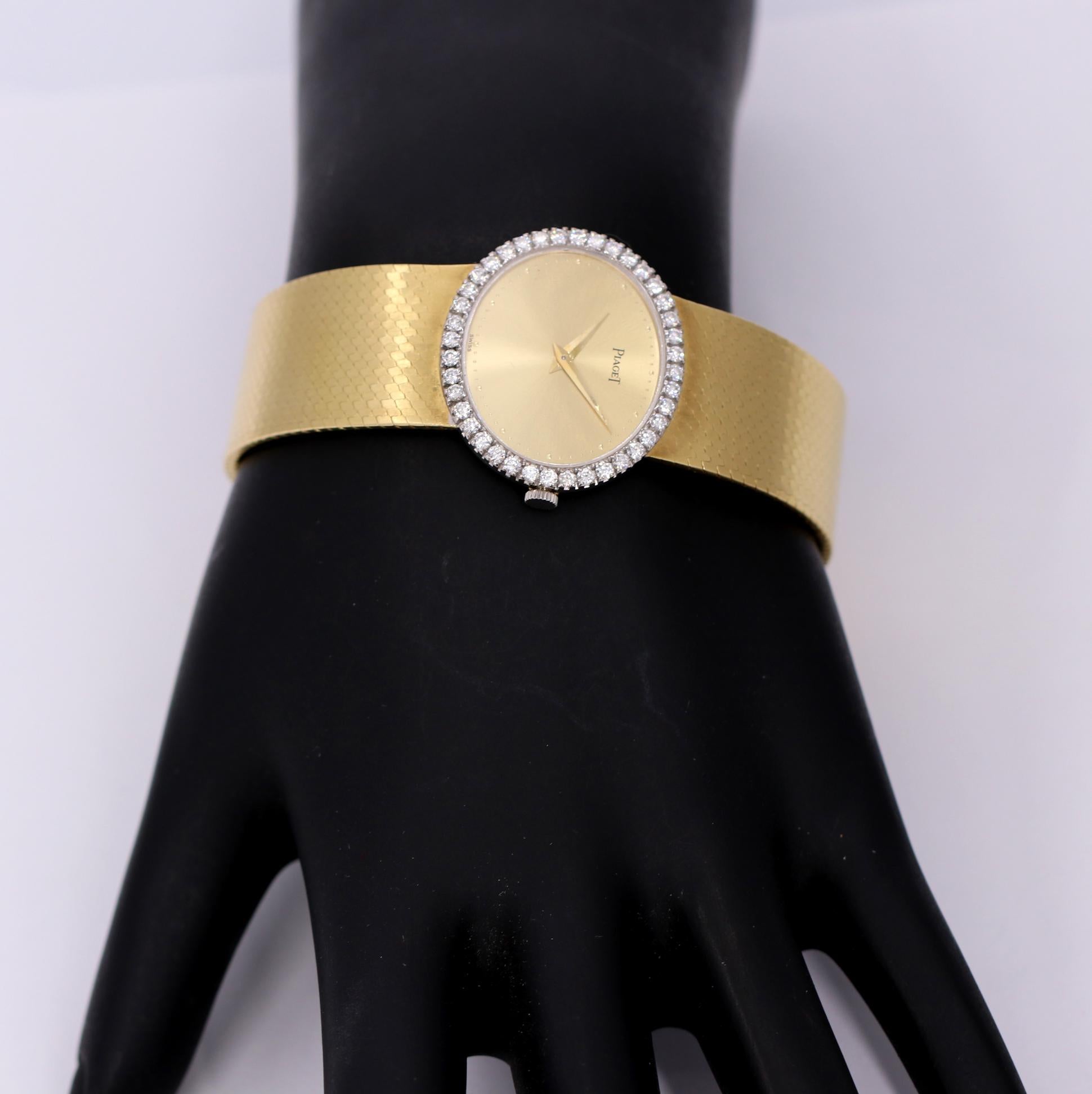 A ladies 18K yellow gold wristwatch, set with 40 round brilliant cut diamonds. Measuring a little over an inch wide this horizontal oval watch features a champagne gold dial. This vintage watch will fit a wrist up to 6 3/4 inches. Overall weight is