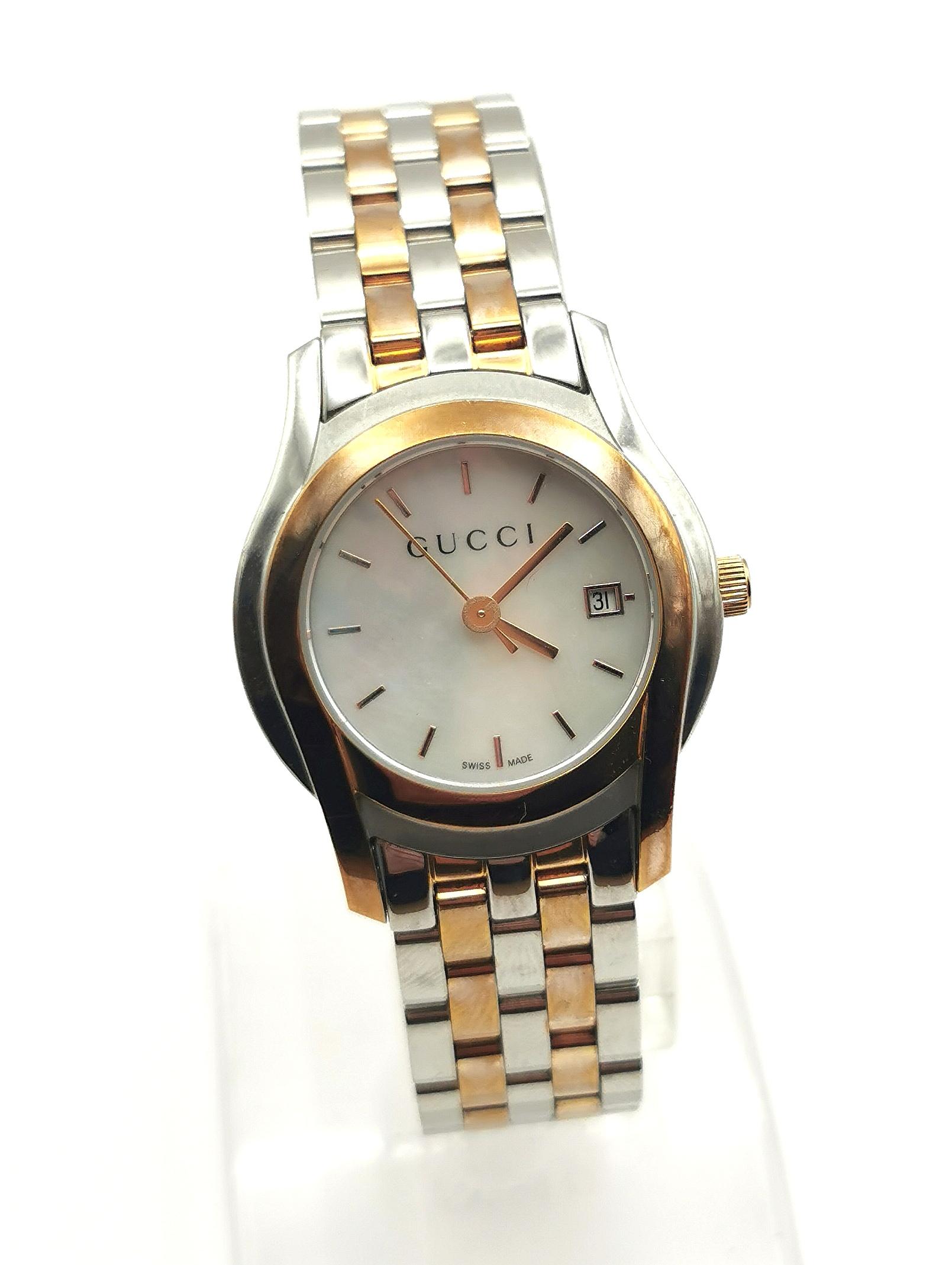 A stylish Gucci 5500L stainless steel watch.

This is a bracelet strap watch with a nice chunky stainless steel and gold plated brick link bracelet strap.

The case is stainless steel with a gold plated bezel, pearlescent dial with no numerals and