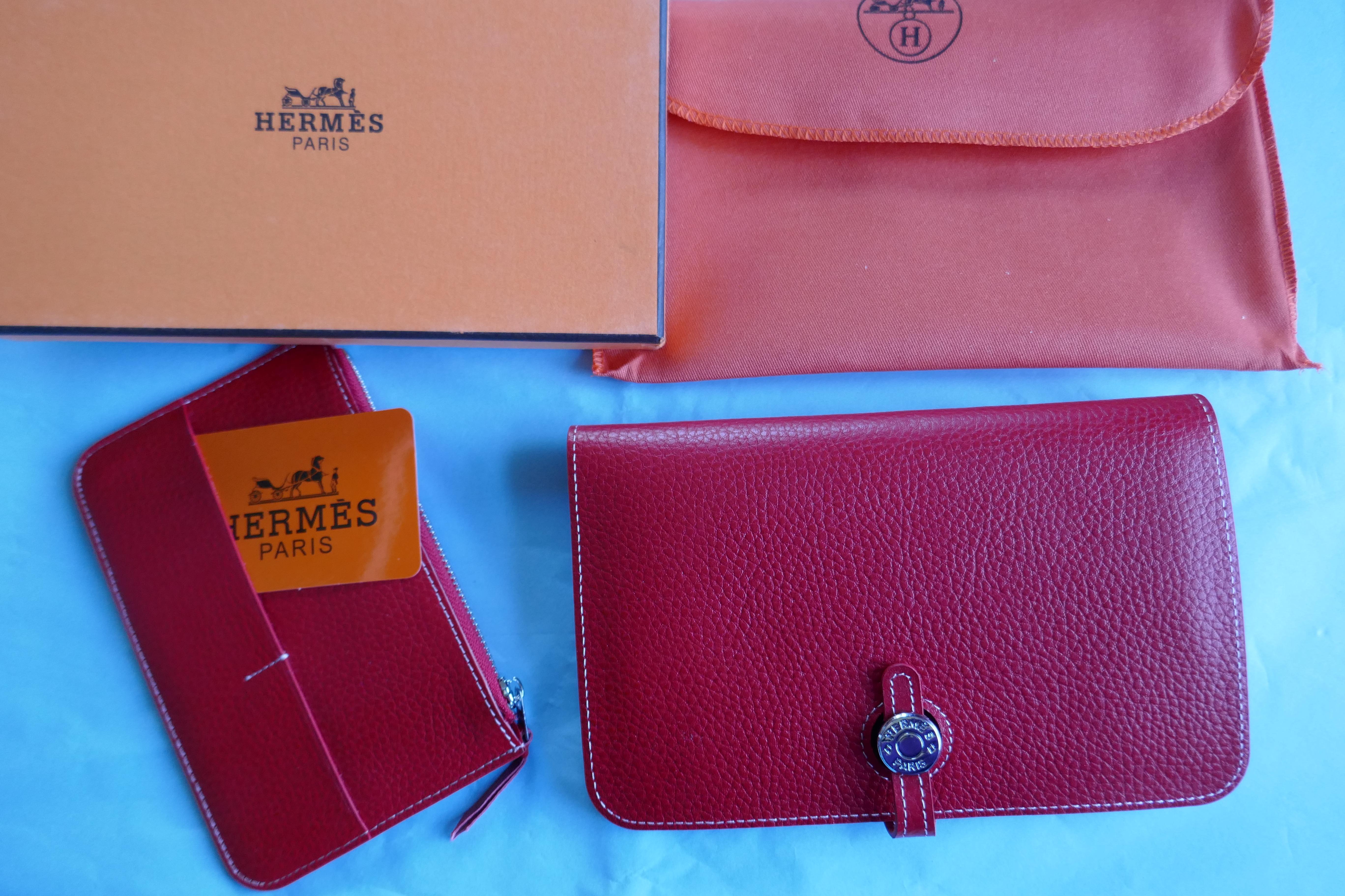 Ladies Hermes Paris Red Togo Calfskin Dogon Duo Wallet with Purse

This beautiful wallet is made from Togo Calfskin and has a silver coloured metal fastening with a leather slide tab, reading 'HERMÈS PARIS’

The wallet has 2 sections, the front with