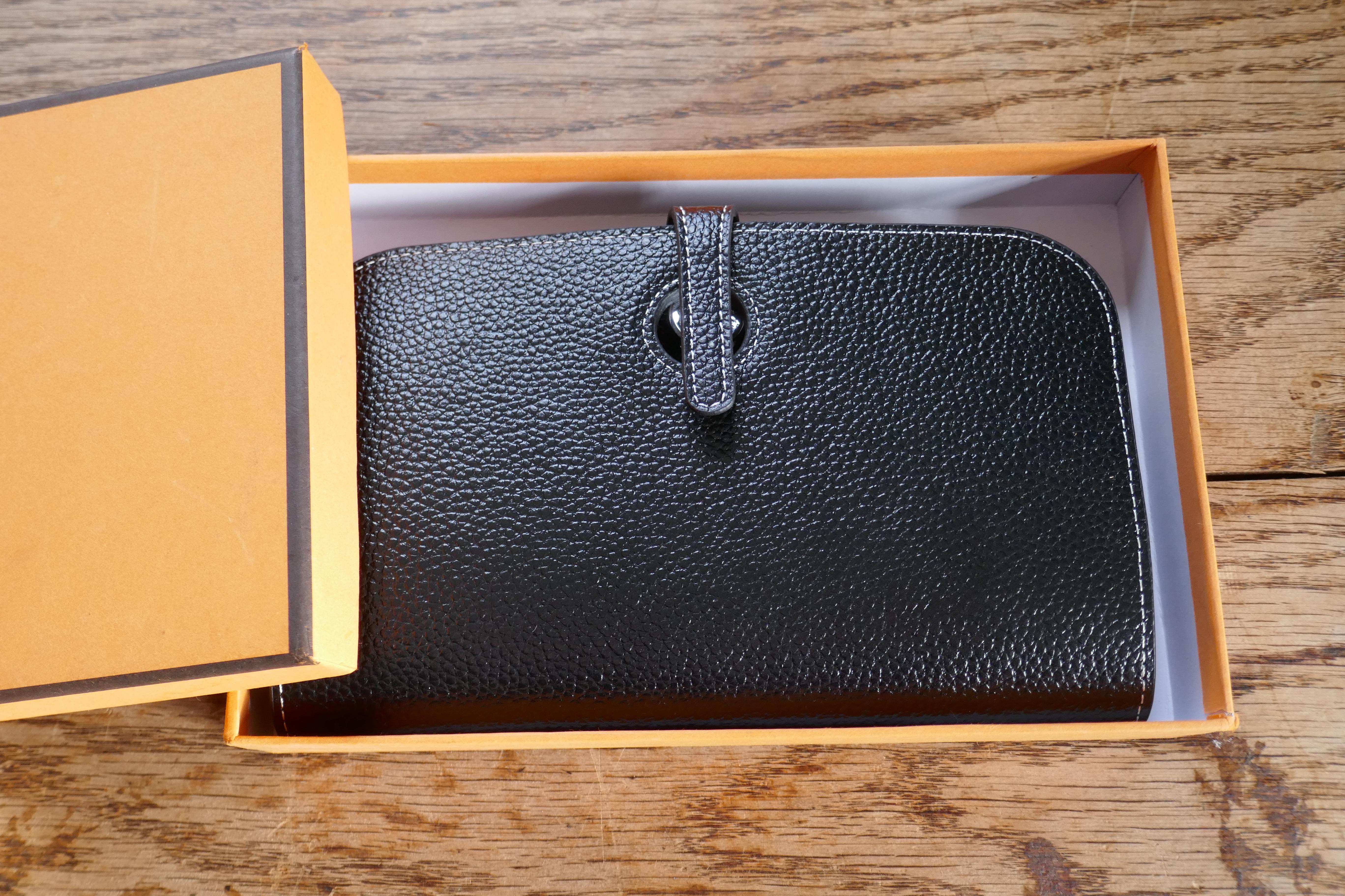 Ladies Hermes Shiny Black Togo Calfskin Dogon Duo Wallet with Purse  

This beautiful wallet is made from Togo Calfskin and has a silver coloured metal fastening with a leather slide tab, reading 'HERMÈS PARIS’  The wallet has 2 sections, the front