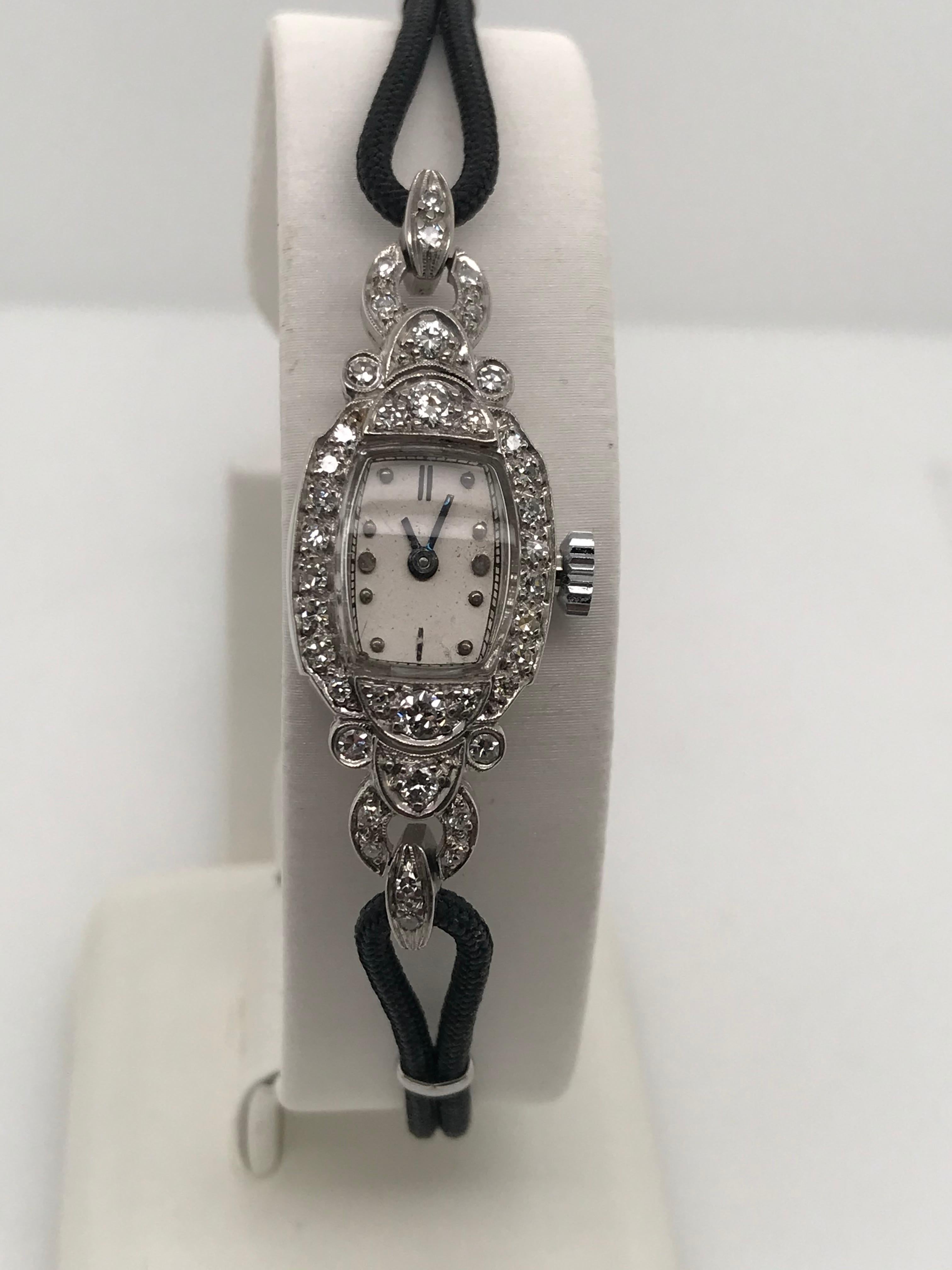 Very rare lady's PALLADIUM Concord watch with a 17 jewel movement.  The watch has 32 single cut diamonds =.64cts and four brilliant cut diamonds=.30cts with a black cord strap.  This elegant watch is secured with a fold over clasp and a safety