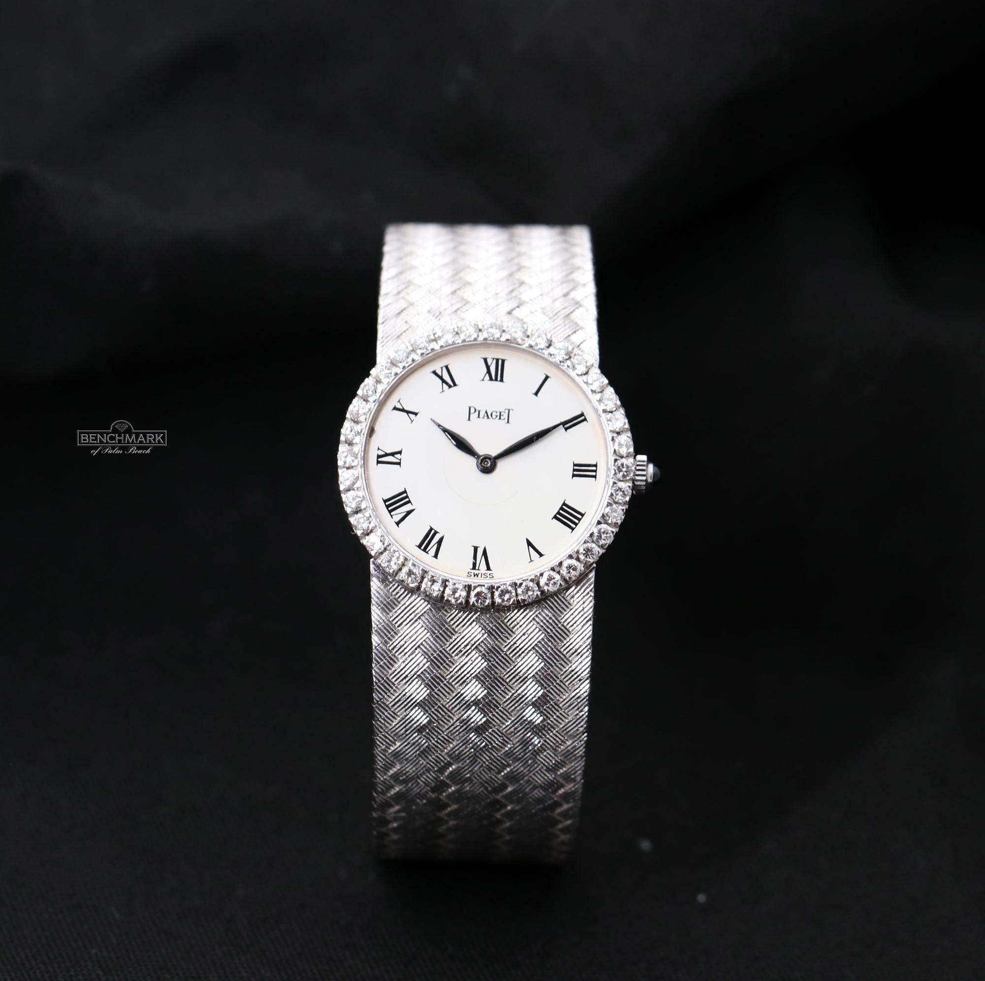 A ladies 18K white gold Piaget wristwatch featuring a white enamel dial with Roman numerals. Surrounding the dial is a bezel set with 36 round brilliant cut diamonds weighing a total of approximately 0.85ct. The bracelet is a beautiful woven design,