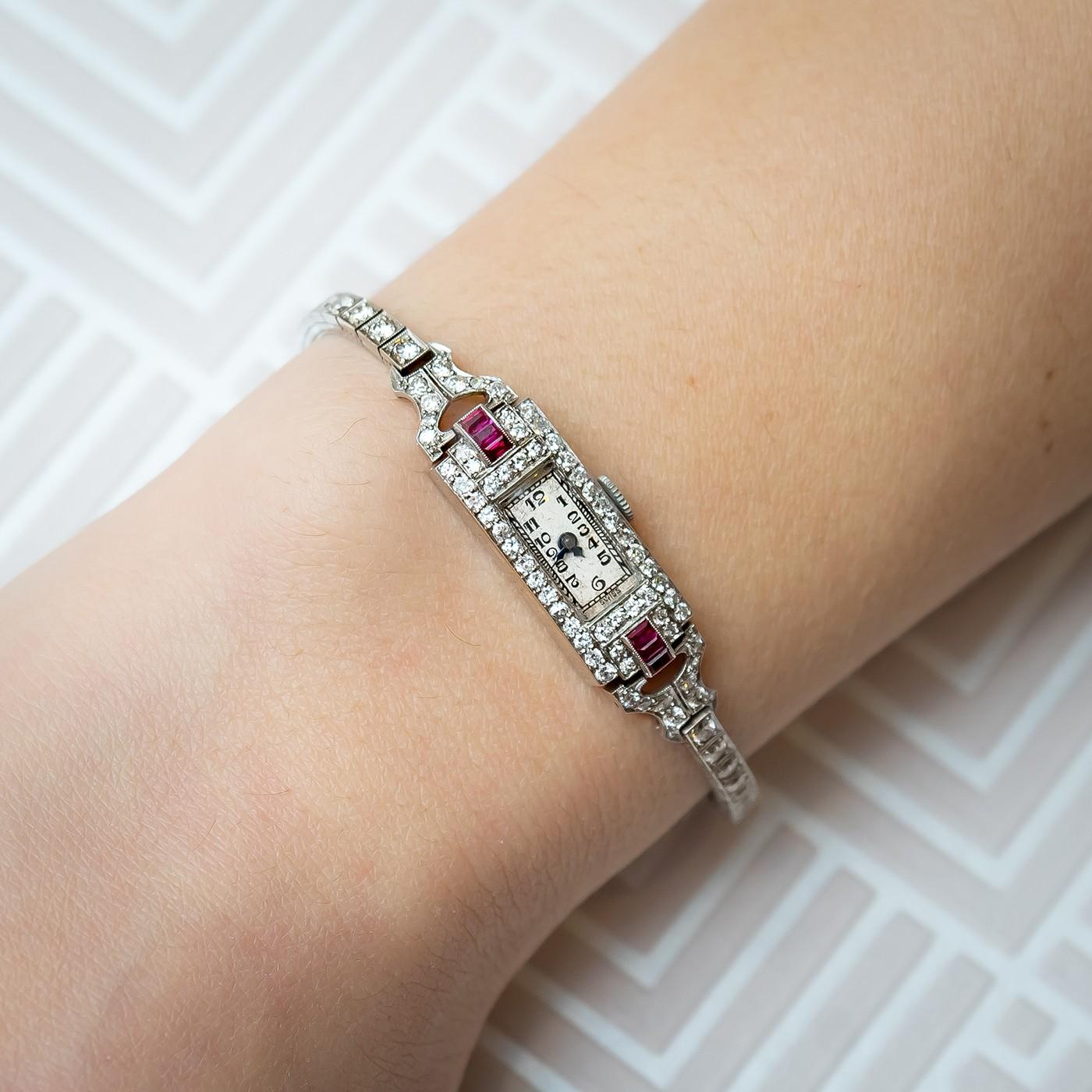 Ruby and diamond cocktail wristwatch, rectangular dial with dial with Arabic numerals, surrounded by round brilliant-cut diamonds with three baguette cut rubies to the lugs, platinum case, on a platinum diamond set bracelet, 17 jewel Accurist manual