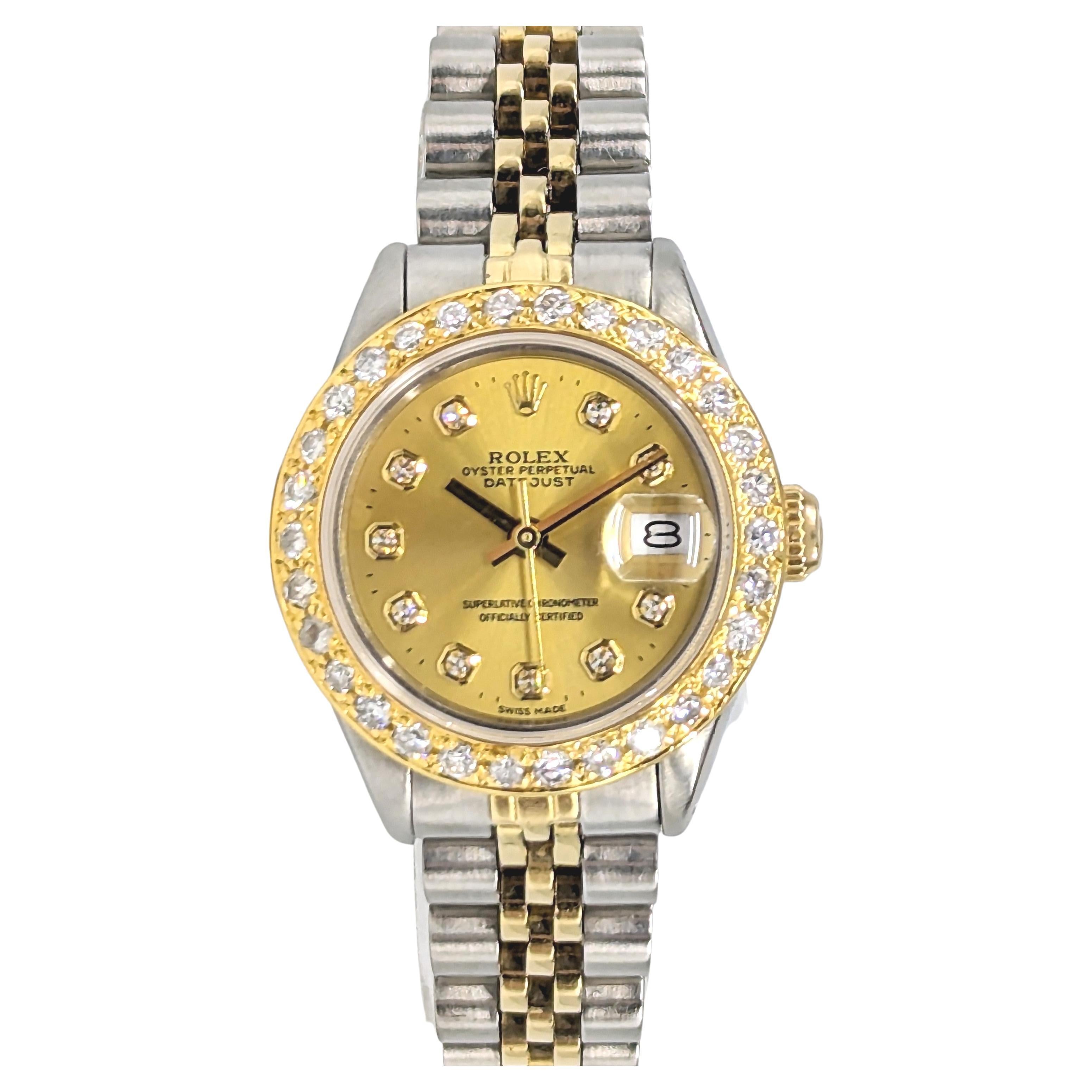 An elegant ladies Rolex in 2 tone yellow gold and stainless steel, with a 2 tone Rolex jubilee bracelet. The dial is gold, custom set with aftermarket diamond markers. The aftermarket bezel is solid gold, custom set with approx 1.3 ctw. of round cut