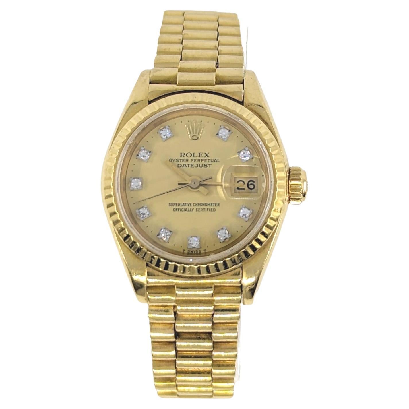 An elegant ladies Rolex with factory diamond dial in solid 18k yellow gold with a solid 18k yellow gold presidential bracelet, hidden clasp. The Rolex dial is gold, set with diamond markers. The Swiss made Rolex quickset movement is automatic