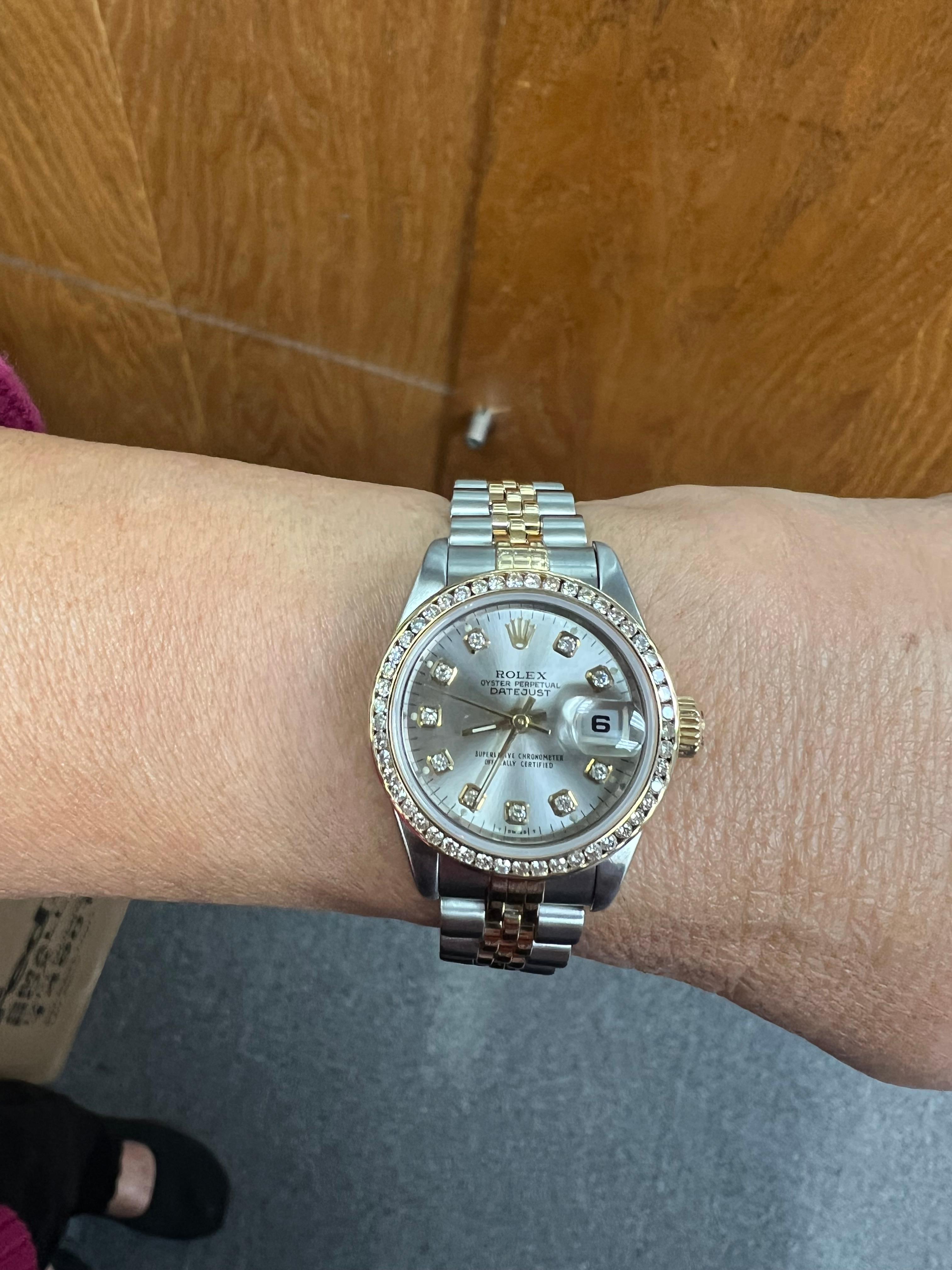 Ladies Rolex Datejust Two-Tone Wristwatch from 2003.

This Rolex Datejust Ladies' watch, was crafted in stainless steel and 18k yellow gold. The watch features an aftermarket high quality diamond bezel and hour markers, with a date display at 3
