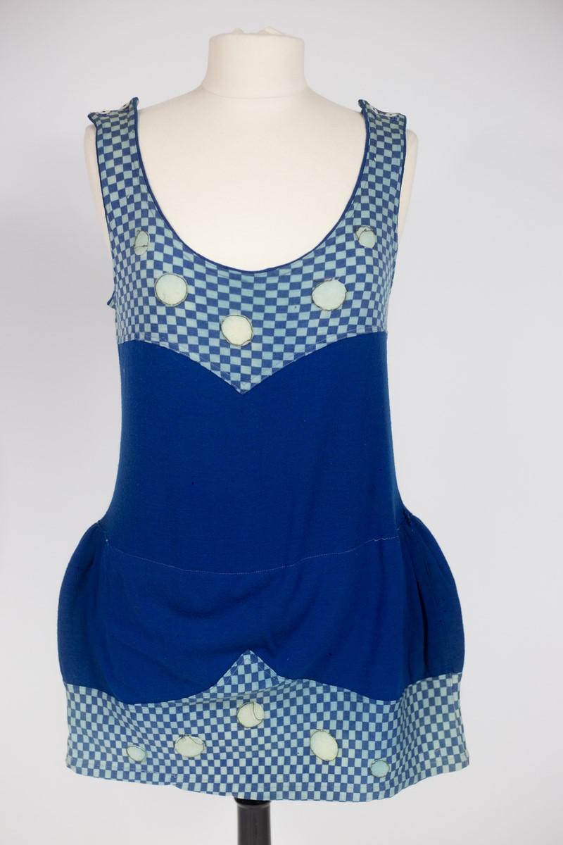 Circa 1910
Francia
Costume da bagno da donna risalente al periodo del turismo balneare della French Belle Epoque. Maglia di lana e cotone blu reale stampata con motivi a scacchi blu e celesti. Costume da bagno intero senza maniche con scollo a barca