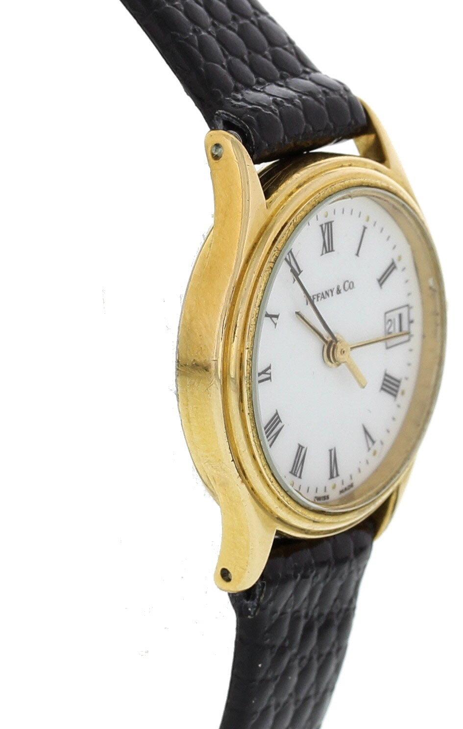 Ladies Tiffany & Co. Portfolio. Gold toned 23mm case. White dial with a date display. Quartz battery movement. Comes with a Tiffany box.
