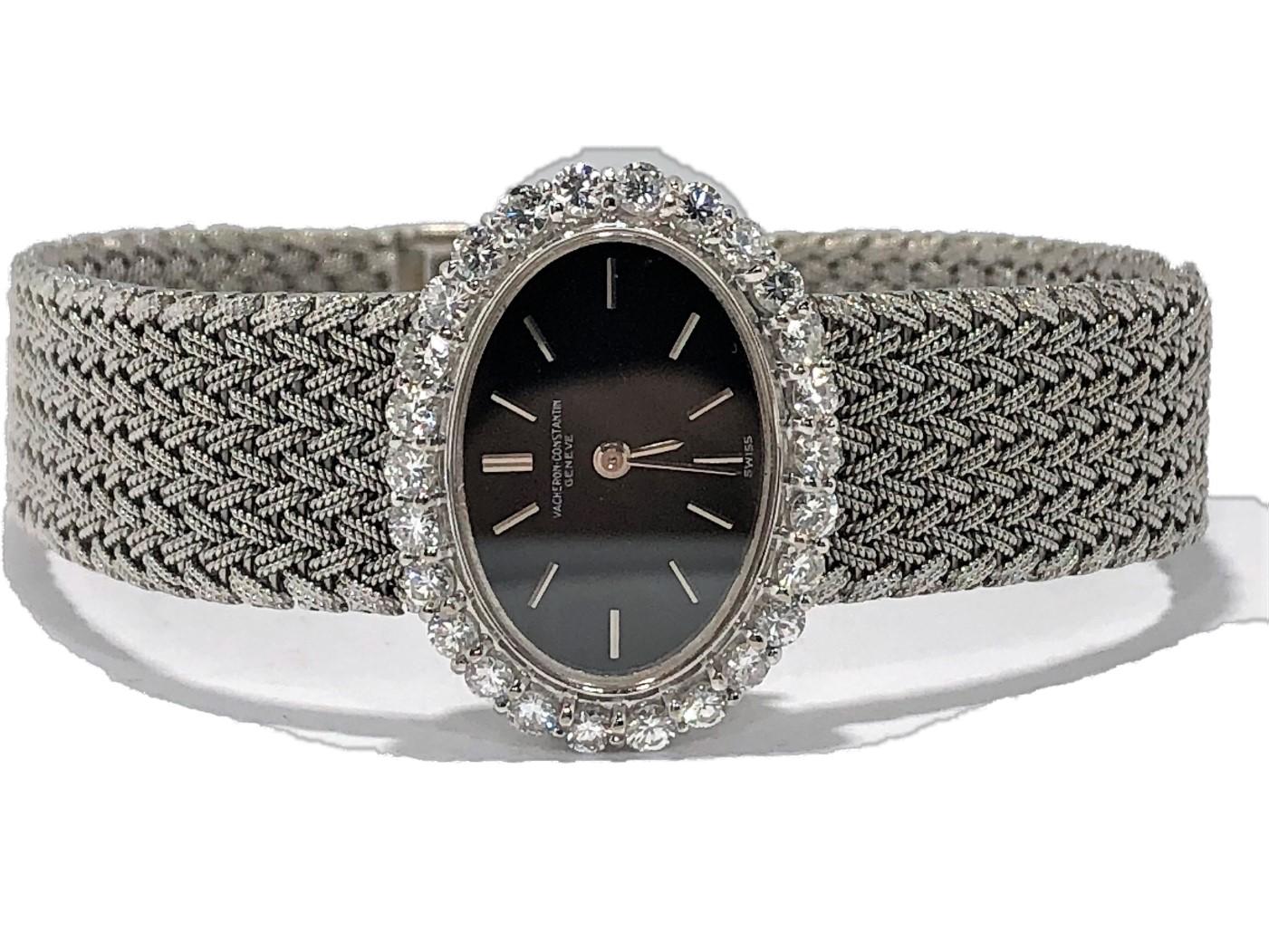 Classic in design, this tailored, 18K White Gold  ladies mid-size 
Vacheron Constantin watch has a horizontal, oval shaped black dial 
accented by crisp white gold markers, surrounded by a bezel of 
scintillating round diamonds. The bezel weighs an