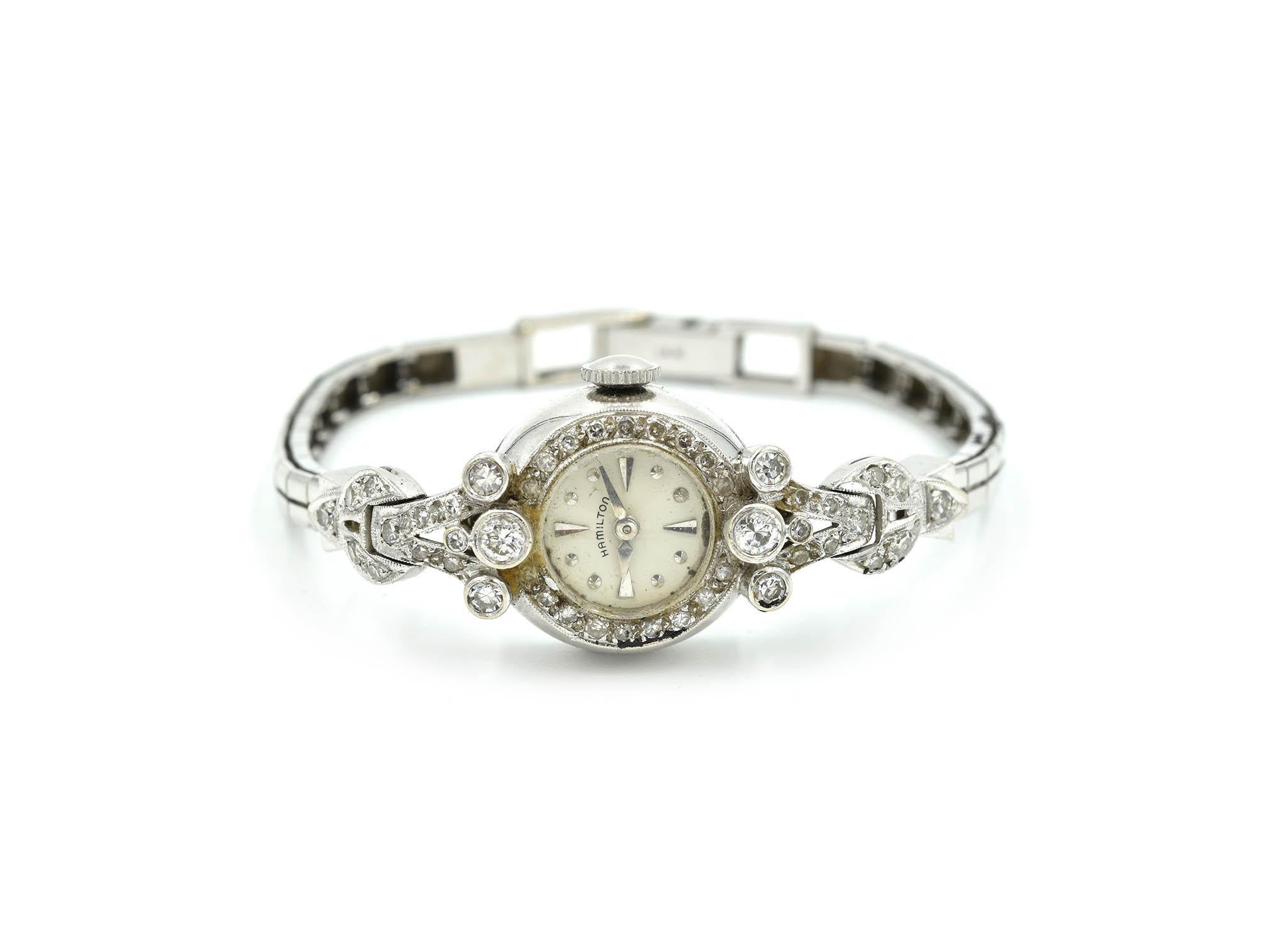 Movement: manual wind
Function: hours, minutes
Case: 16mm 14k white gold oval shaped case, round diamond case and lugs, glass protective crystal, pull/push crown, diamonds weigh 1.00 carats
Dial: white dial with silver hour markers, silver