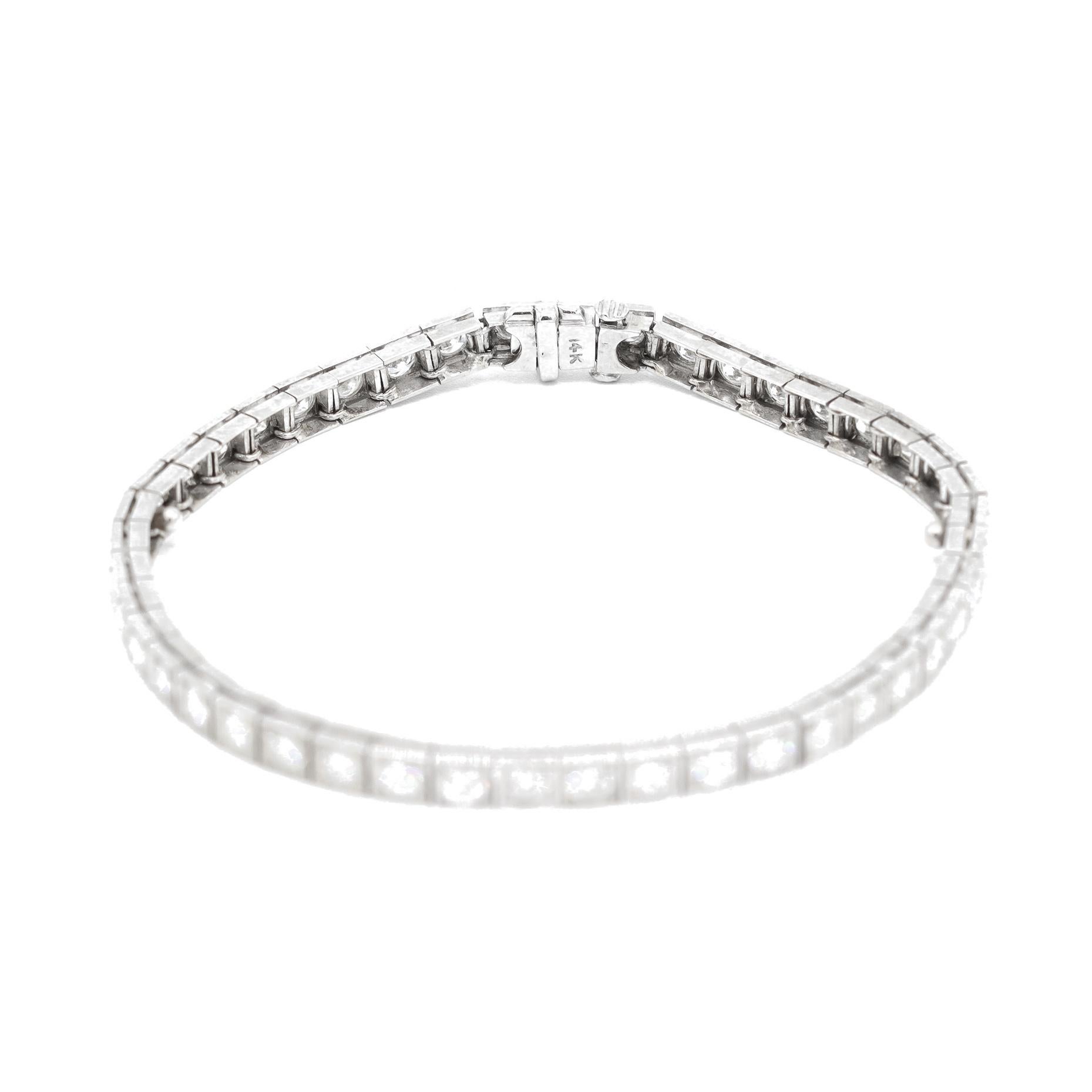 One lady's custom made filigreed 14K white gold, diamond tennis bracelet. The bracelet measures approximately 7.00 inches in length by 3.30mm in diameter and weighs a total of 10.20 grams. Engraved with 